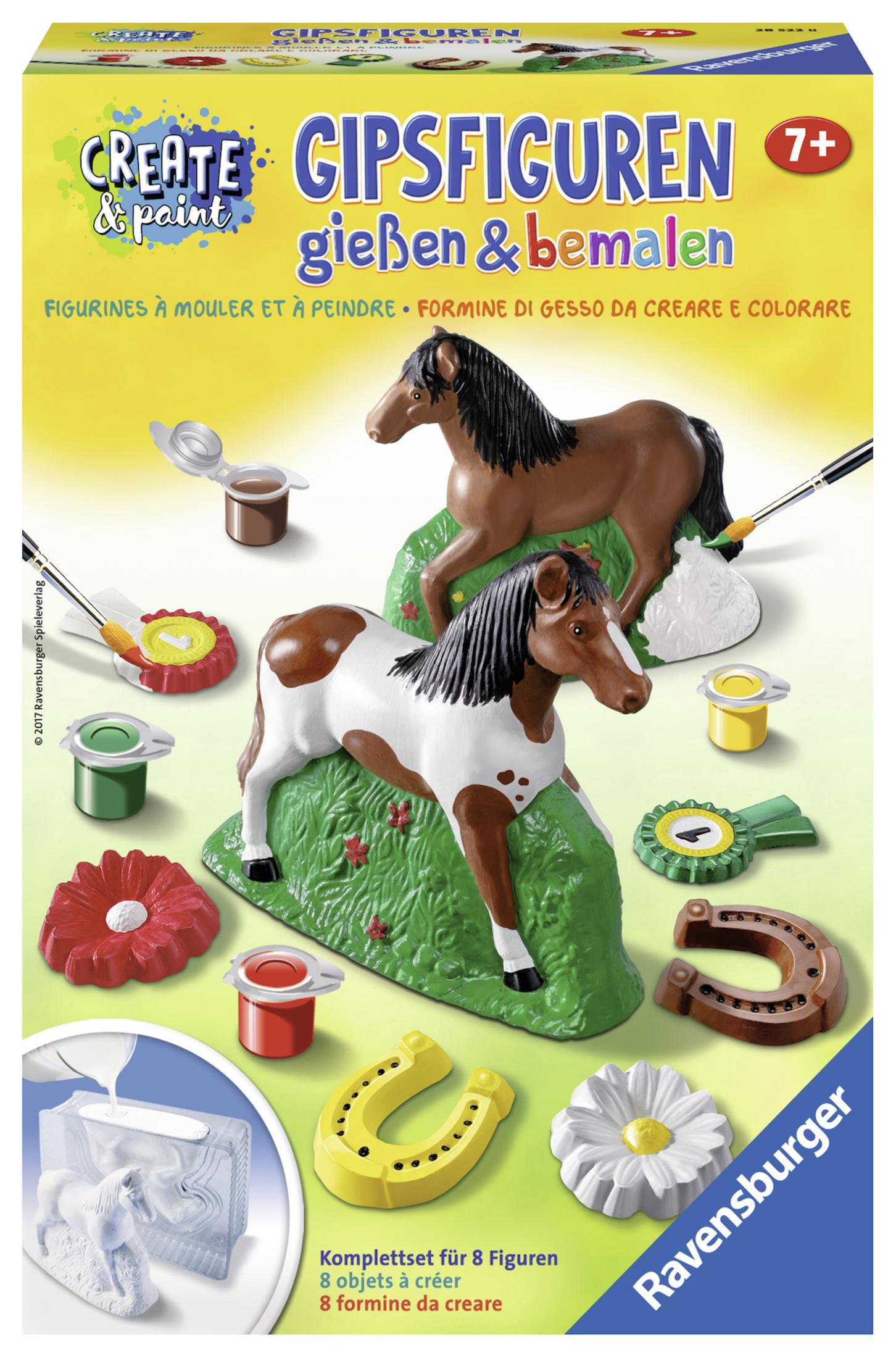 Eine Box mit Pferdfiguren und Malutensilien. Weißer Hintergrund.