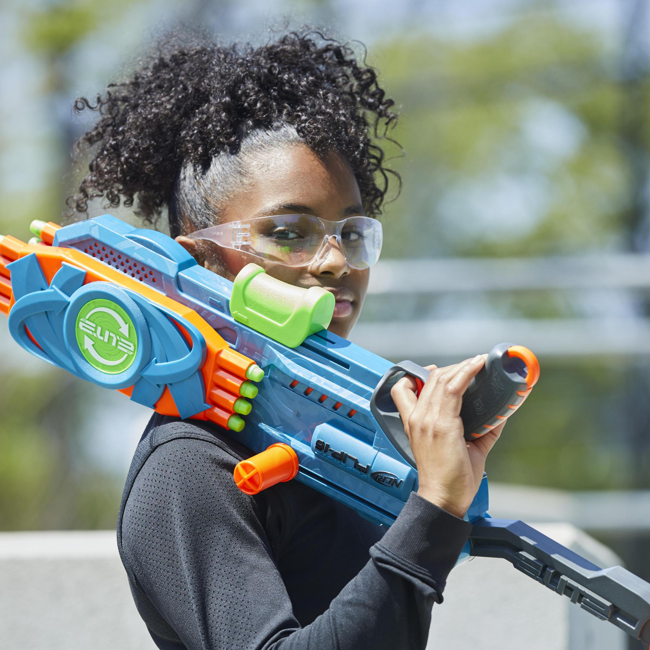 Młoda kobieta w okularach ochronnych trzymająca pistolet Nerf.