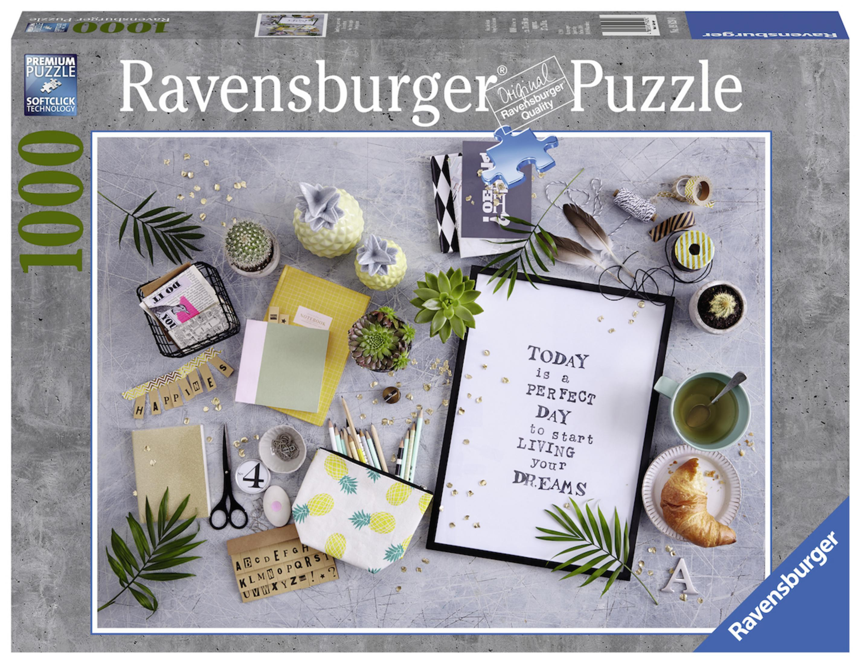 Pudełko puzzli Ravensburger 1000 elementów. Przedmioty na stole: rośliny, notatniki, ołówki, rogalik i oprawiony cytat.