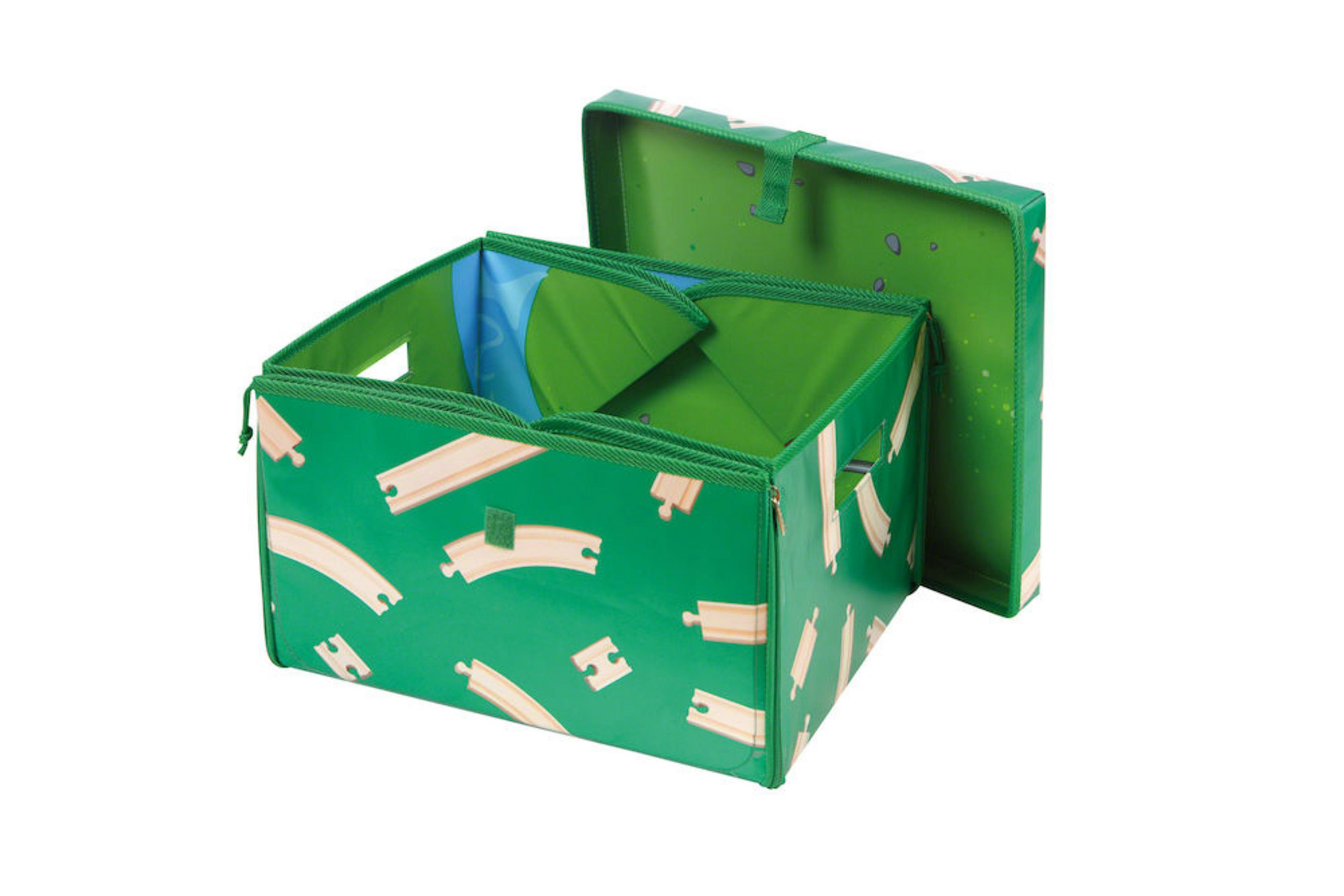 Zielone pudełko do przechowywania z torami kolejki zabawki. Otwarte z pokrywą obok. Białe tło.