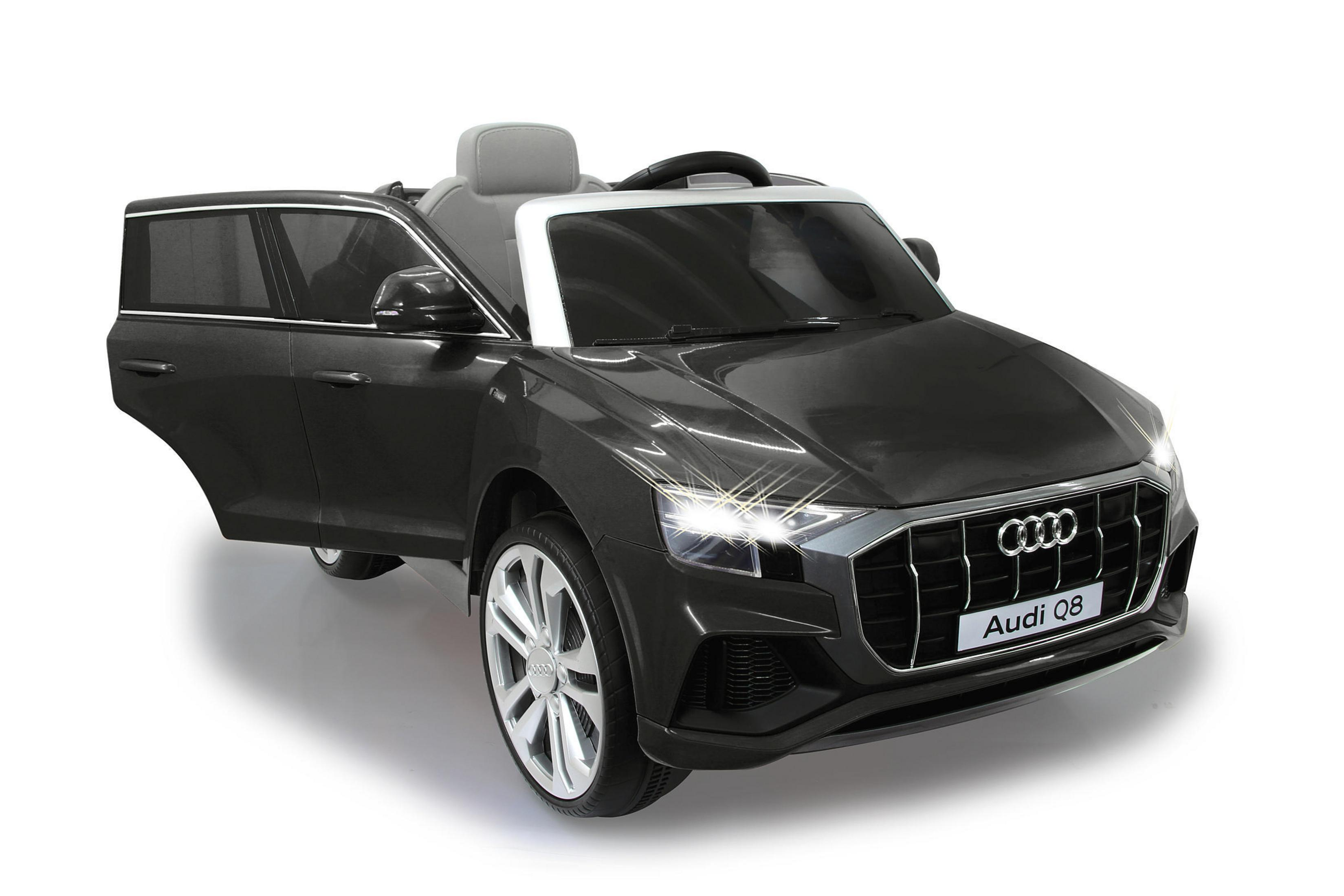 Ein schwarzes Audi Q8 Spielzeugauto mit offener Tür auf weißem Untergrund. Scheinwerfer sind eingeschaltet.