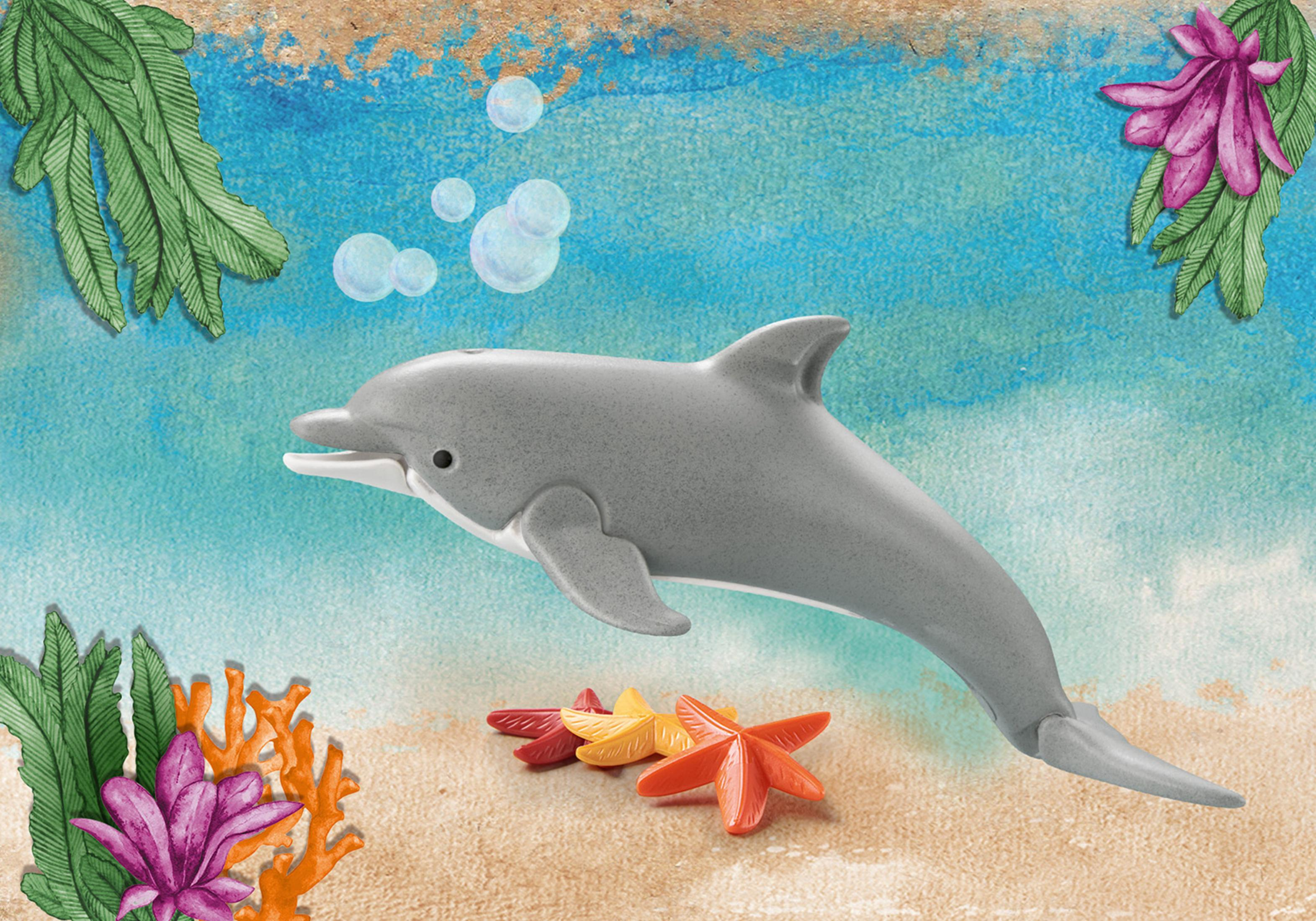Delfin-Spielzeug am Strand. Mit Seesternen, Korallen und Blasen. Blaues Wasser.