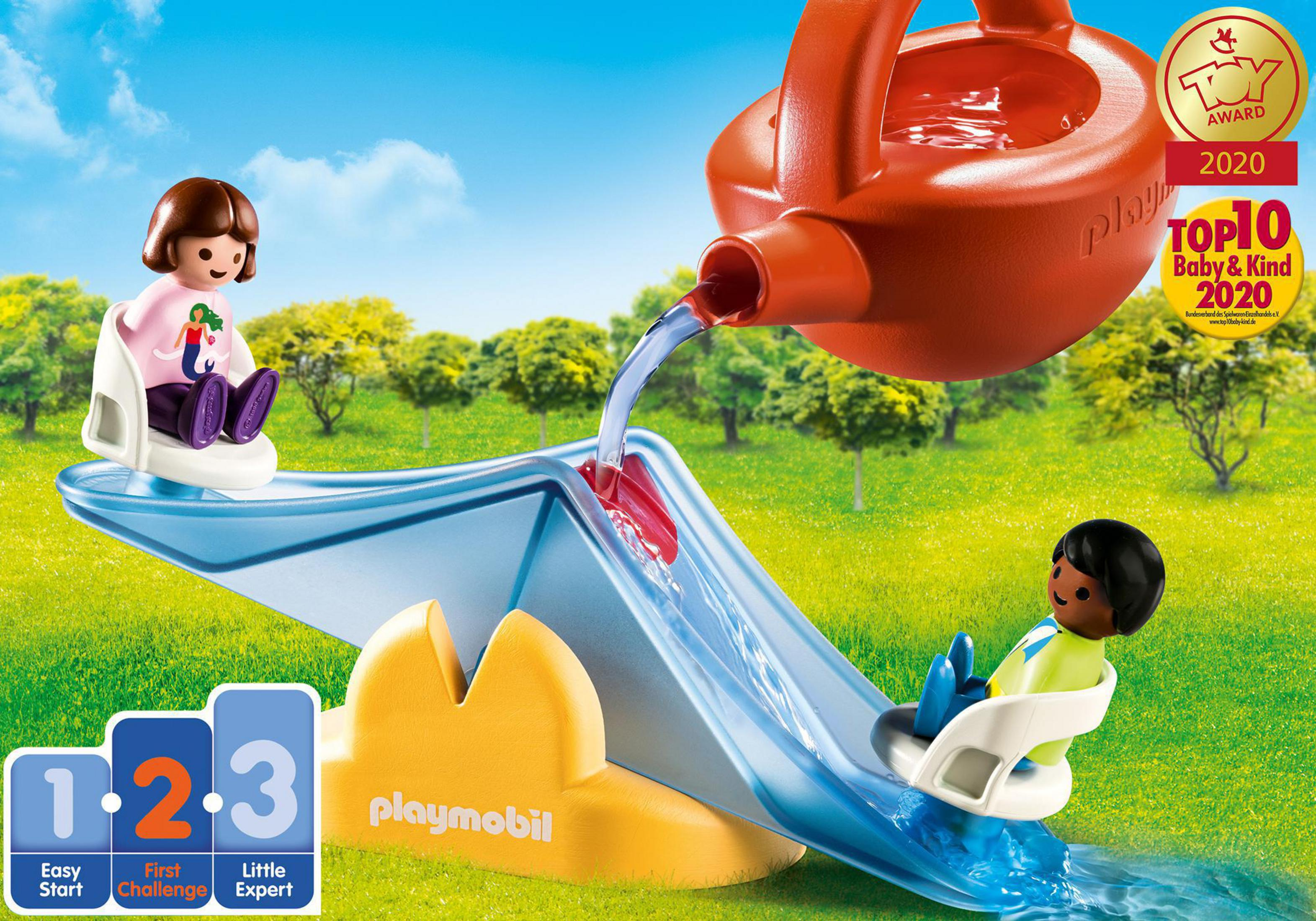 Ein Spielzeug-Spielset mit zwei Kindern und einer Wasserrutsche. Wasser fließt aus einer Gießkanne.