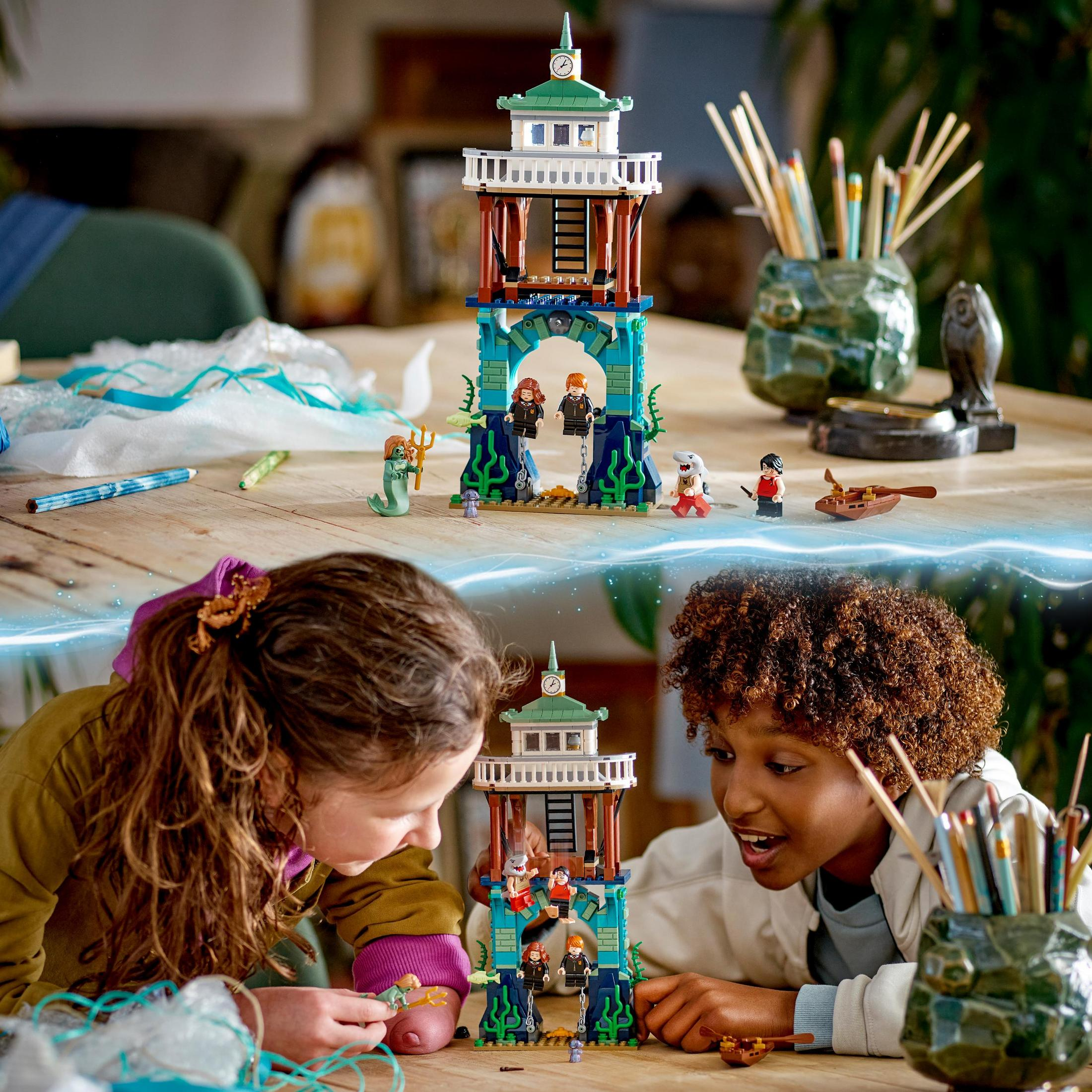 Kinder spielen mit Lego-Set. Ein Leuchtturmturm und einige Minifiguren sind sichtbar.