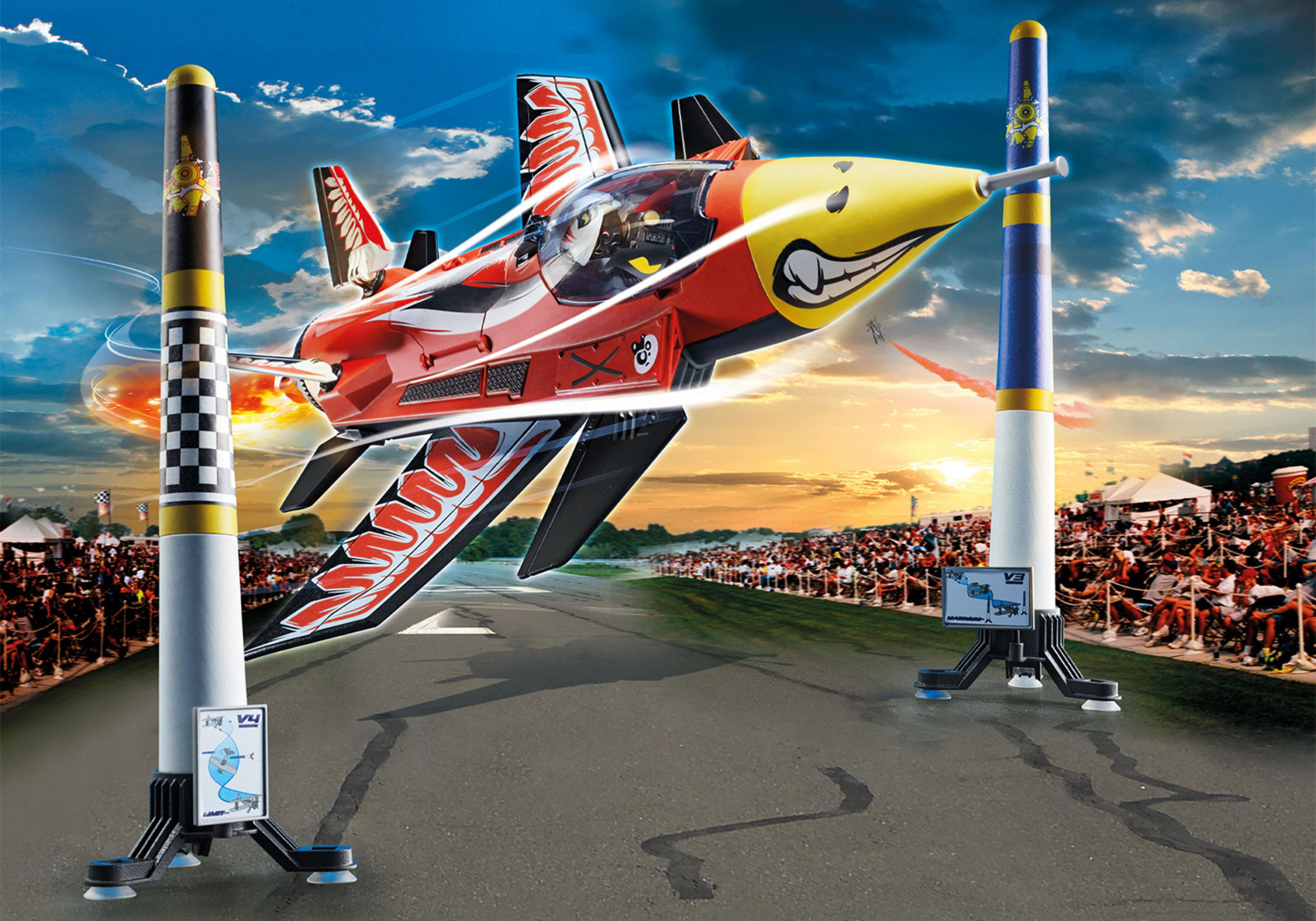 Ein Spielzeugflugzeug im Flug über einer Rennstrecke mit Zuschauern und Pfählen.