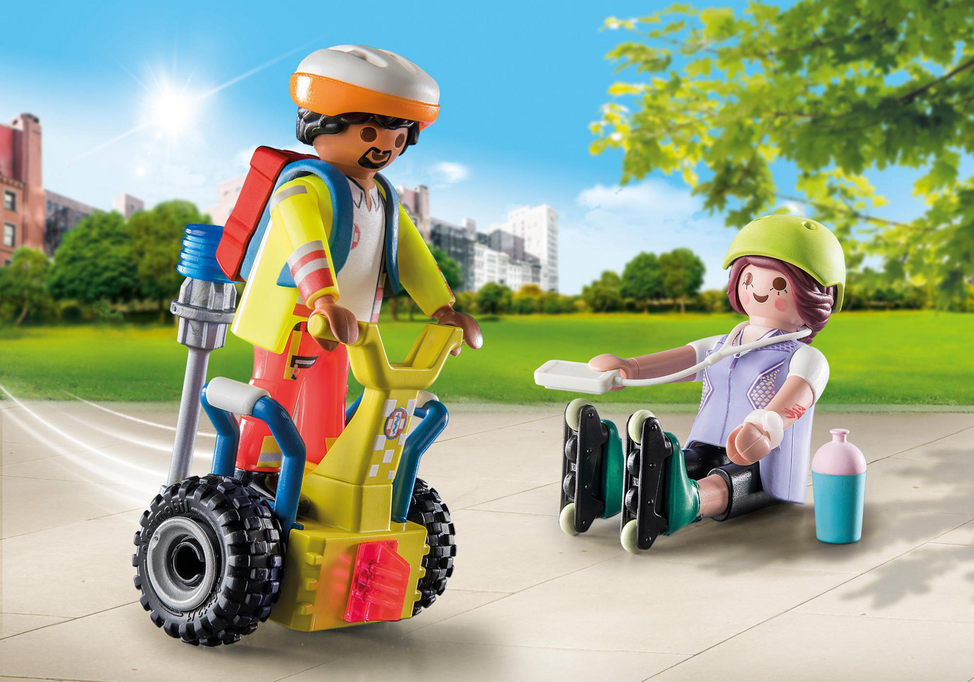 Zwei Playmobil-Figuren auf grünem Untergrund. Einer auf einem Roller, der andere auf Rollschuhen. Grüne Bäume im Hintergrund.