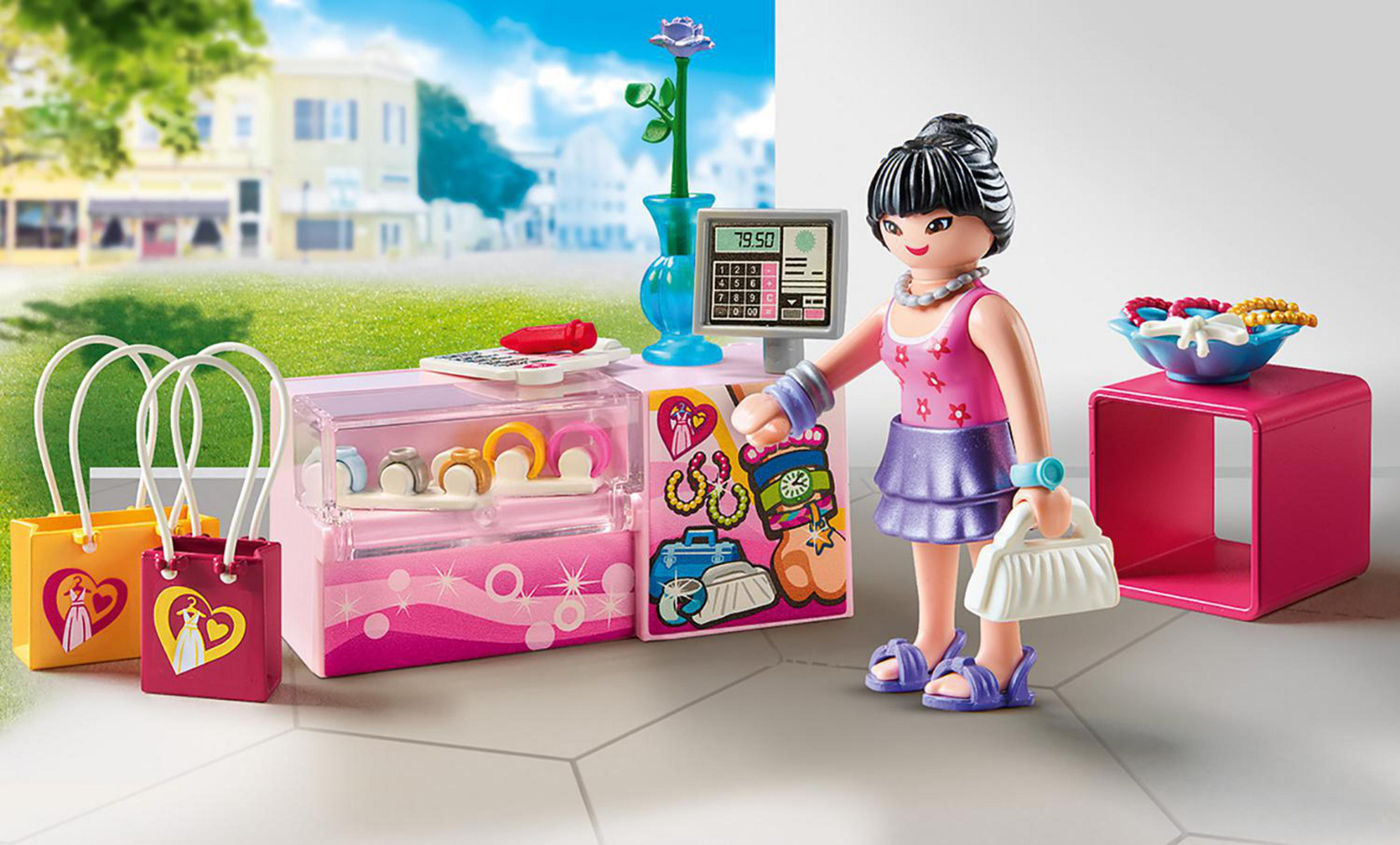 Playmobil-Spielzeugszene. Eine Frau an einer Ladentheke mit Schmuck und Handtaschen.