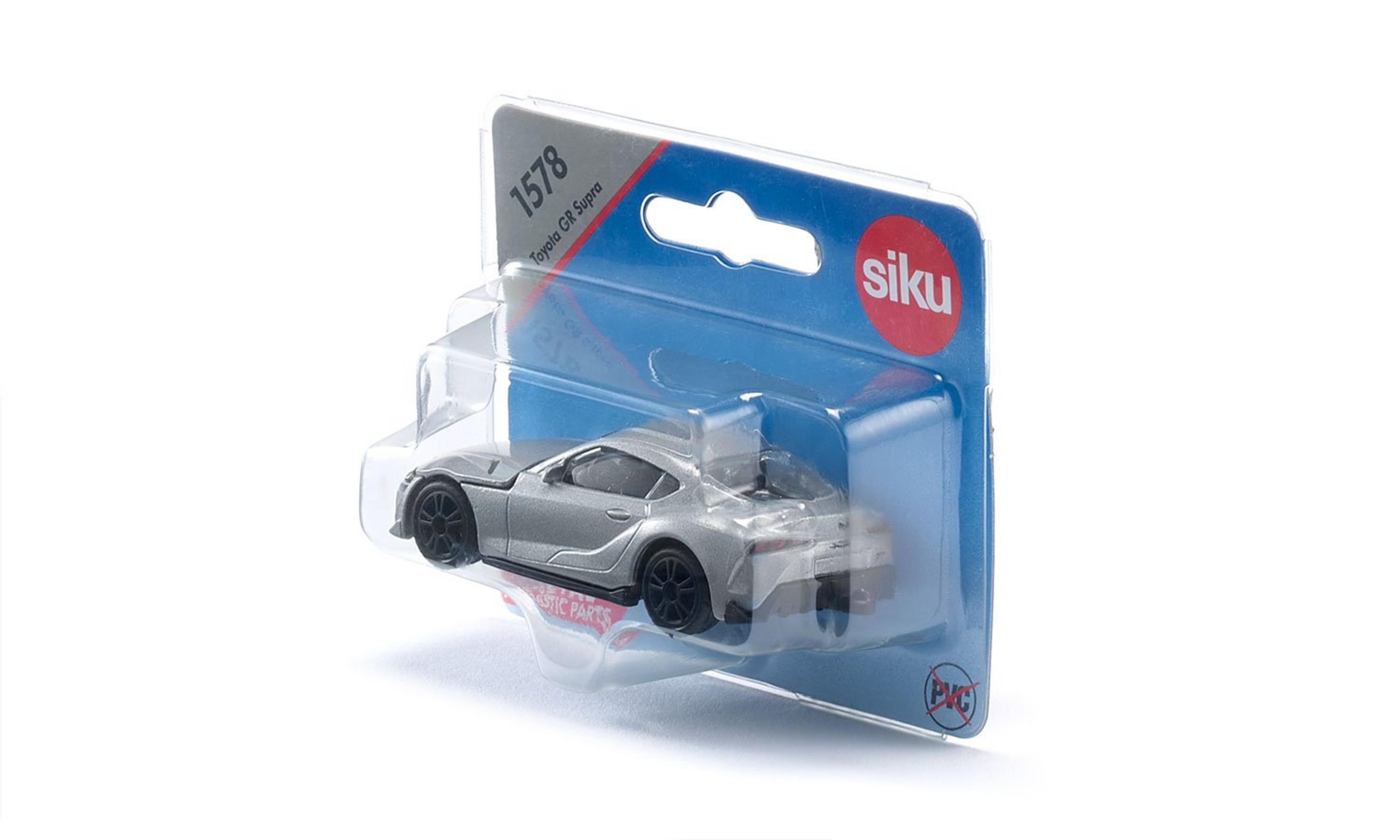 Ein Spielzeugauto in einer durchsichtigen Kunststoffverpackung. Das Auto ist silberfarben und hat schwarze Räder.