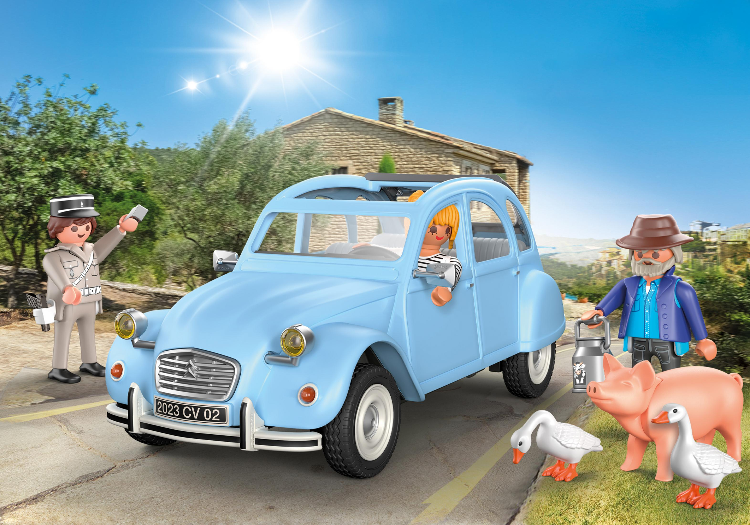 Un'auto Playmobil blu con personaggi in un ambiente rurale con animali da fattoria.