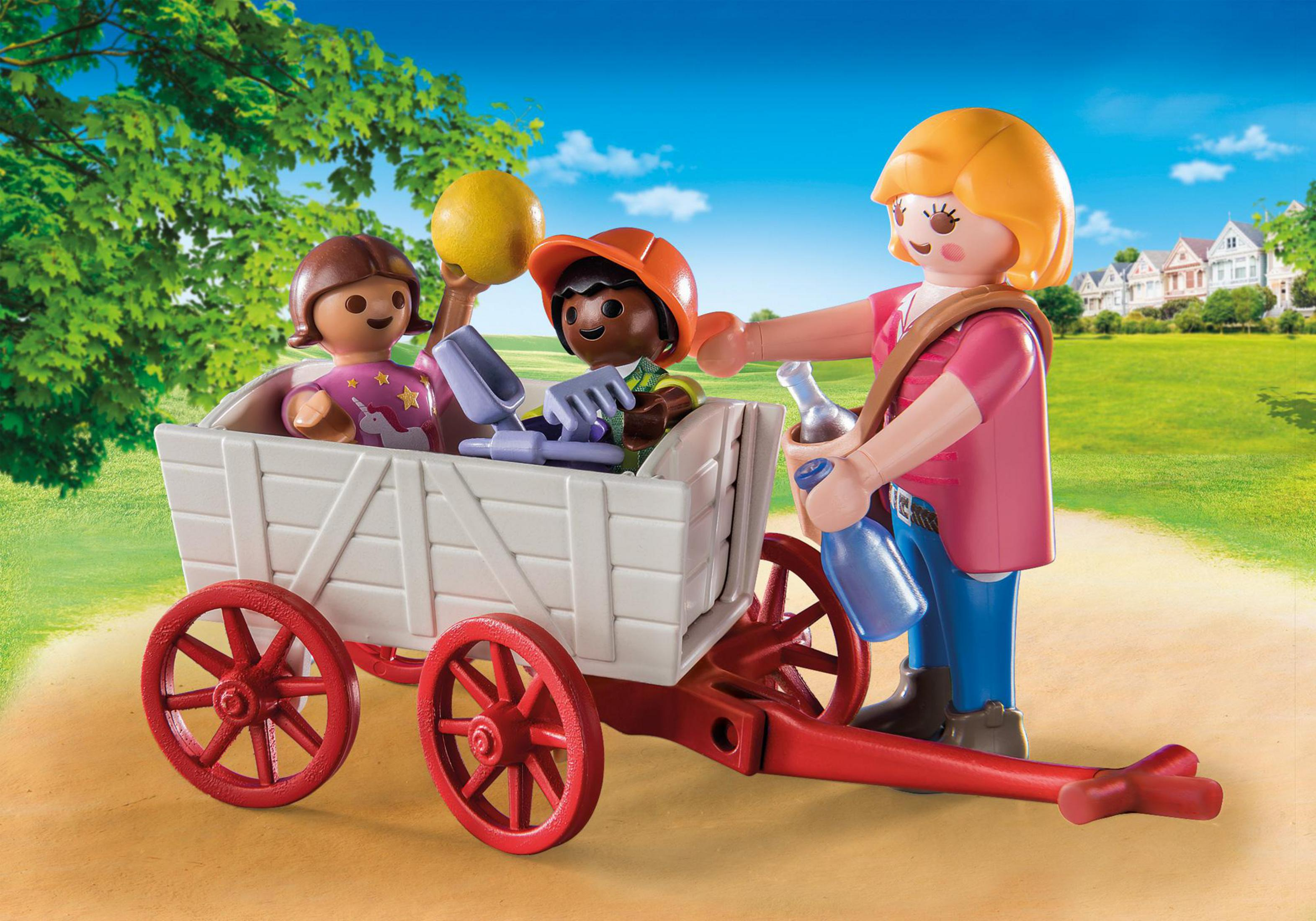 Playmobil-Spielset mit Kindern in einem Wagen, gezogen von einer Frau, auf einem Weg mit Häusern.