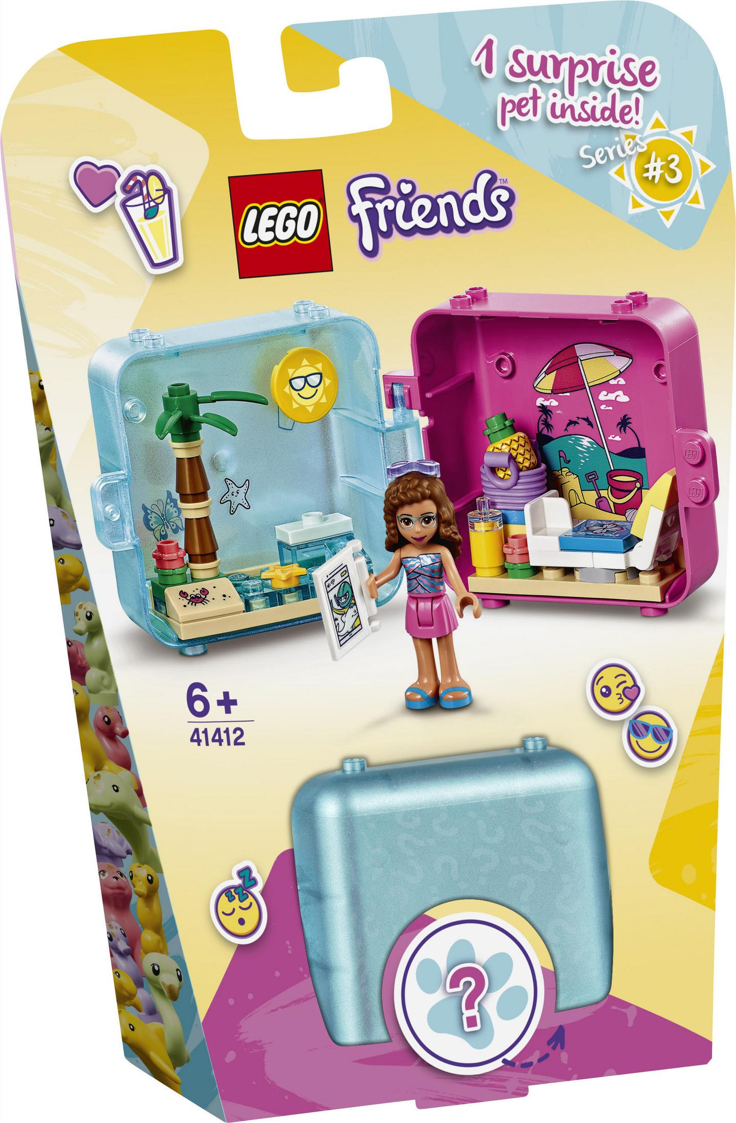 Zestaw Lego Friends. Figurka dziewczynki stoi obok niebiesko-różowej walizki ze sceną plażową w środku.