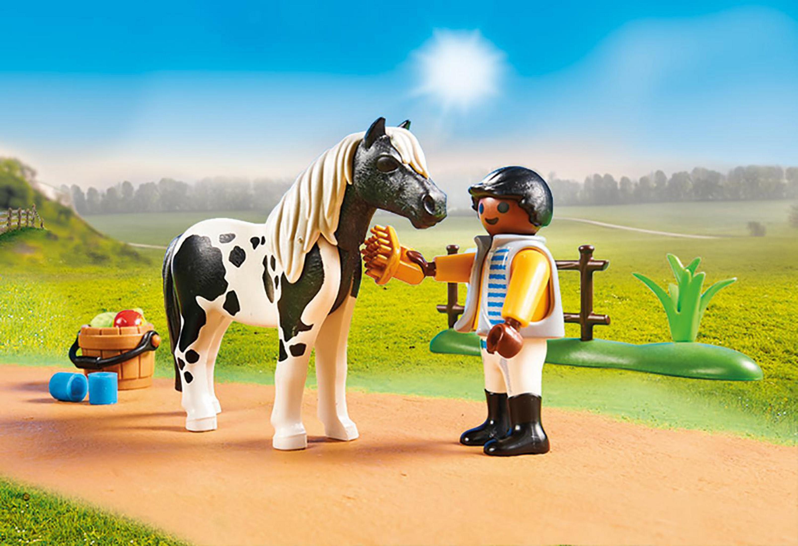 Playmobil-Figur pflegt ein Pferd in einer Feldumgebung, mit Eimer und Zubehör in der Nähe.