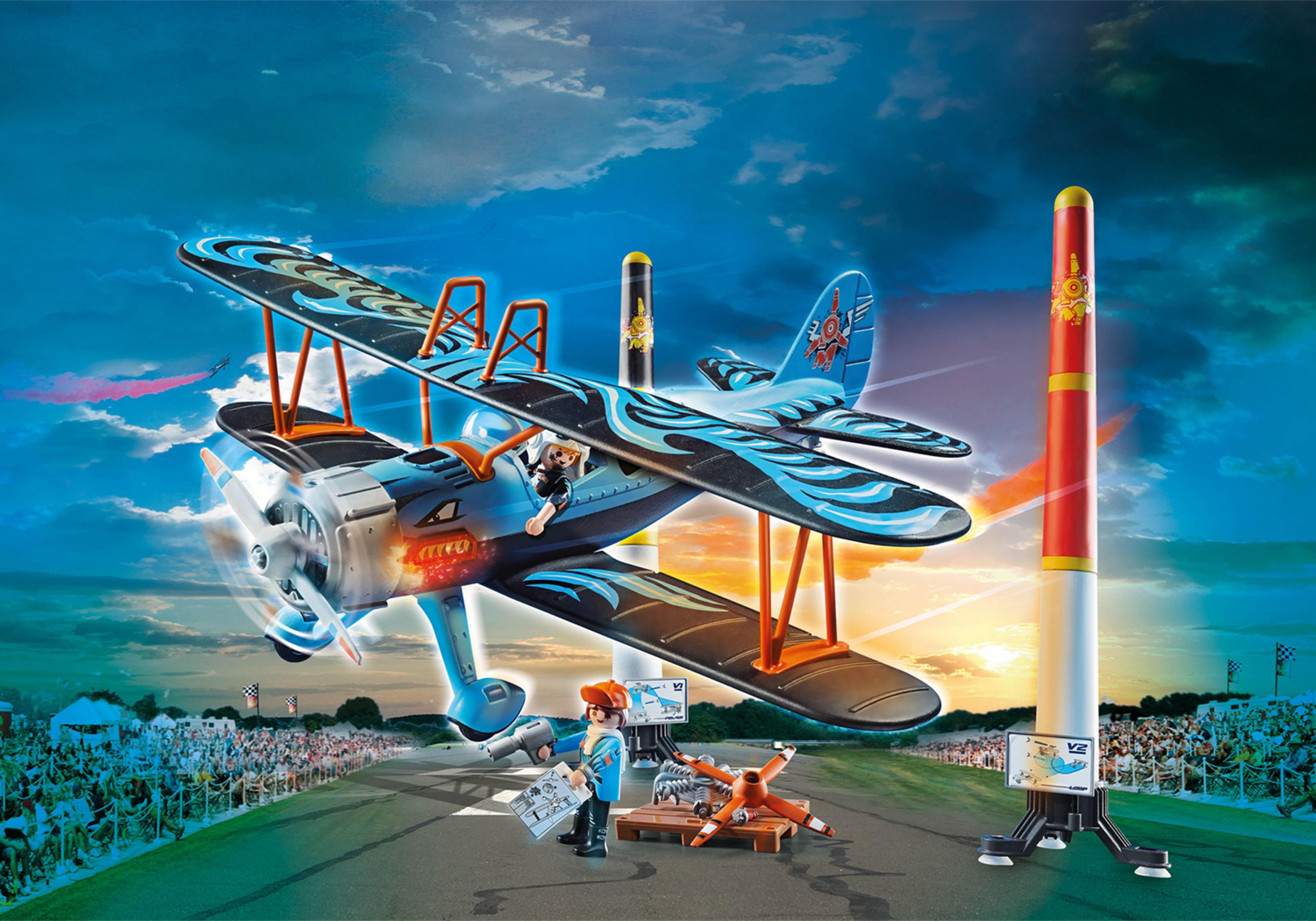 Avión biplano de juguete con diseño naranja y azul, posicionado con figuras de juguete.