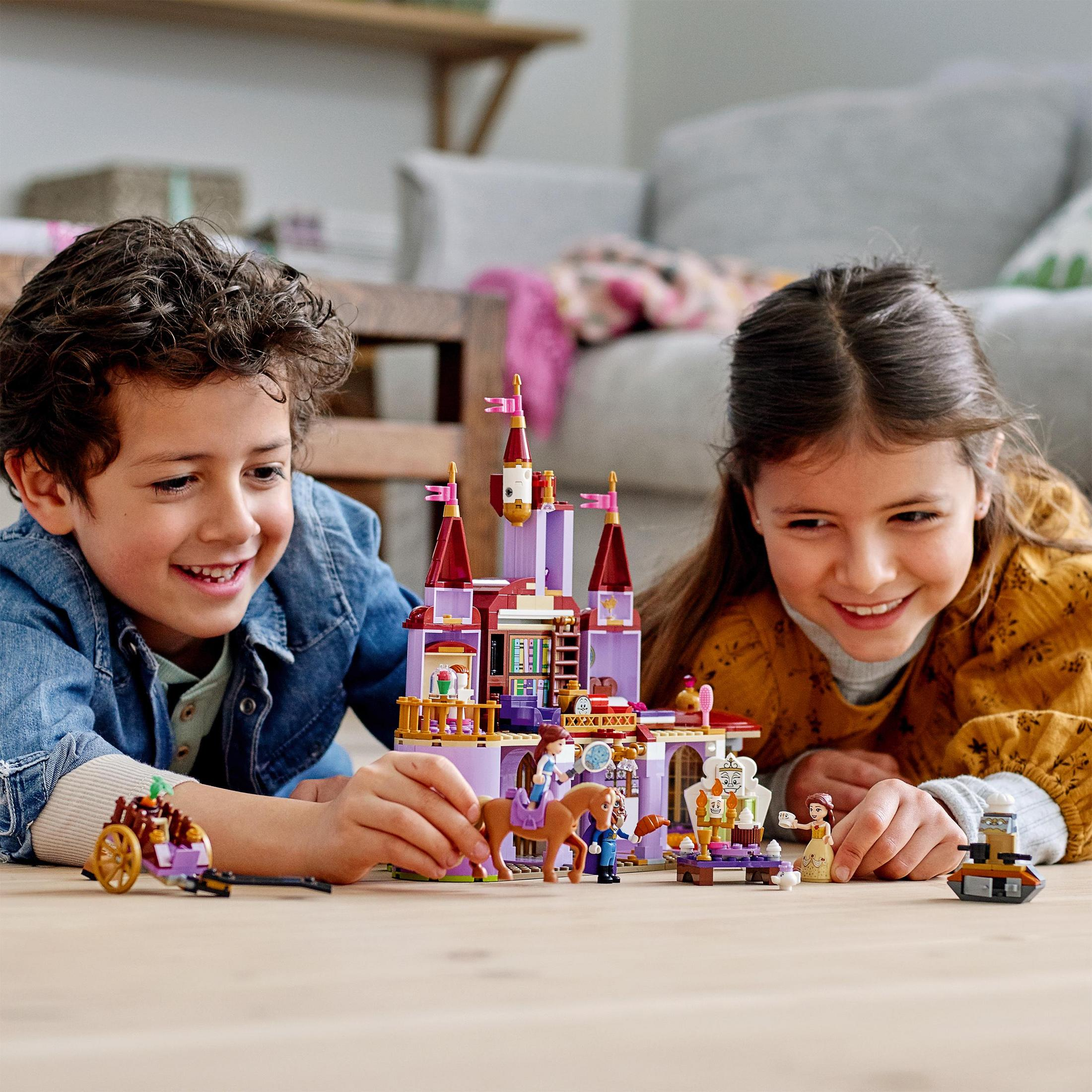 Due bambini giocano con Lego. È un castello. Personaggi Lego e un cavallo.