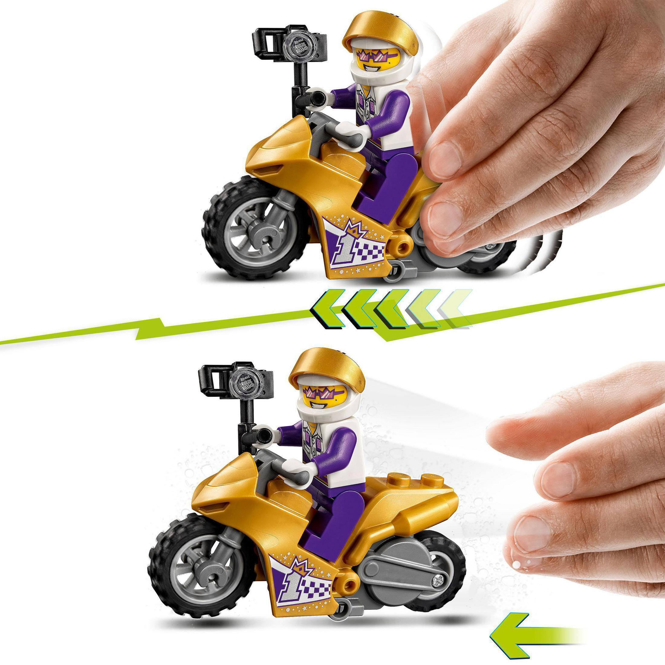 Bir yarışçı figürü ile Lego motosiklet oyuncağı. Eller bir tekerleği çeviriyor ve hareketi gösteriyor.