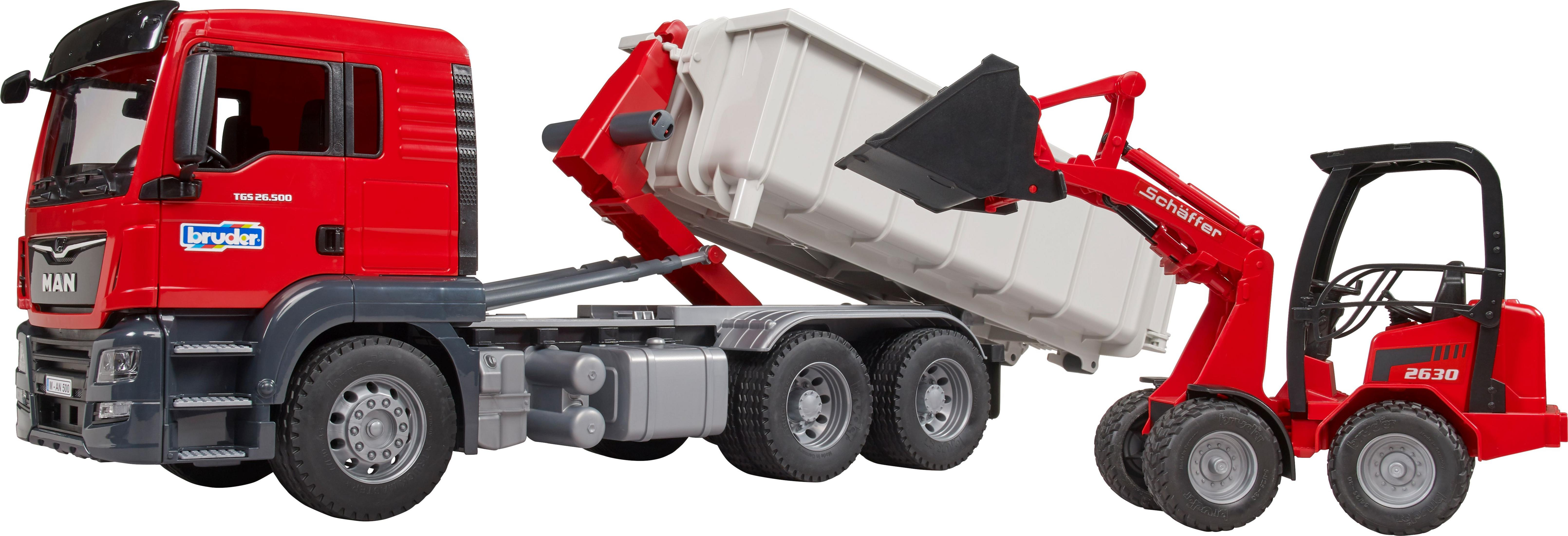 Roter MAN-LKW mit weißem Container, der von einem roten Lader beladen wird.