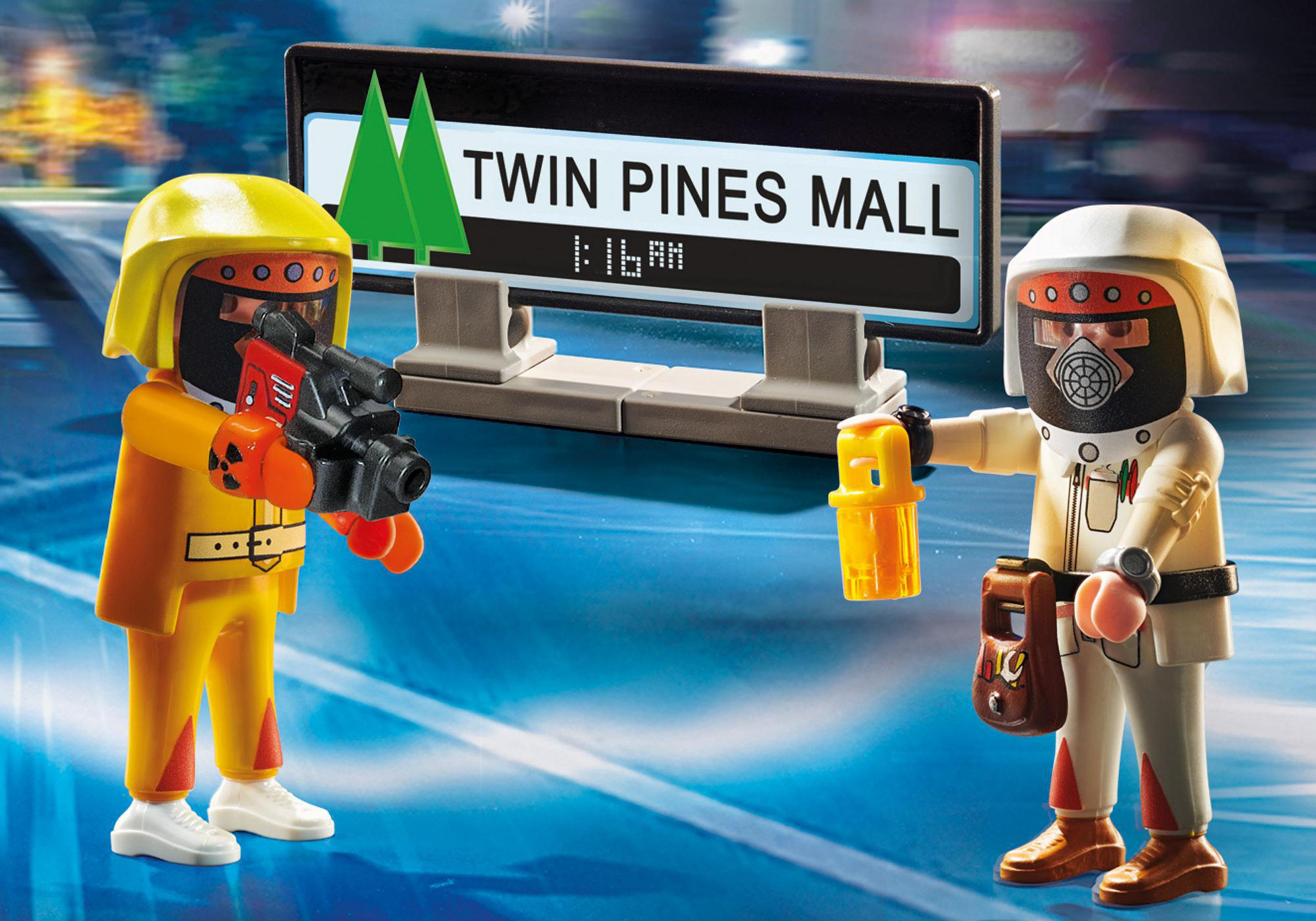 Zwei Spielfiguren in Gefahrgutanzügen stehen an einem Twin Pines Mall Schild.