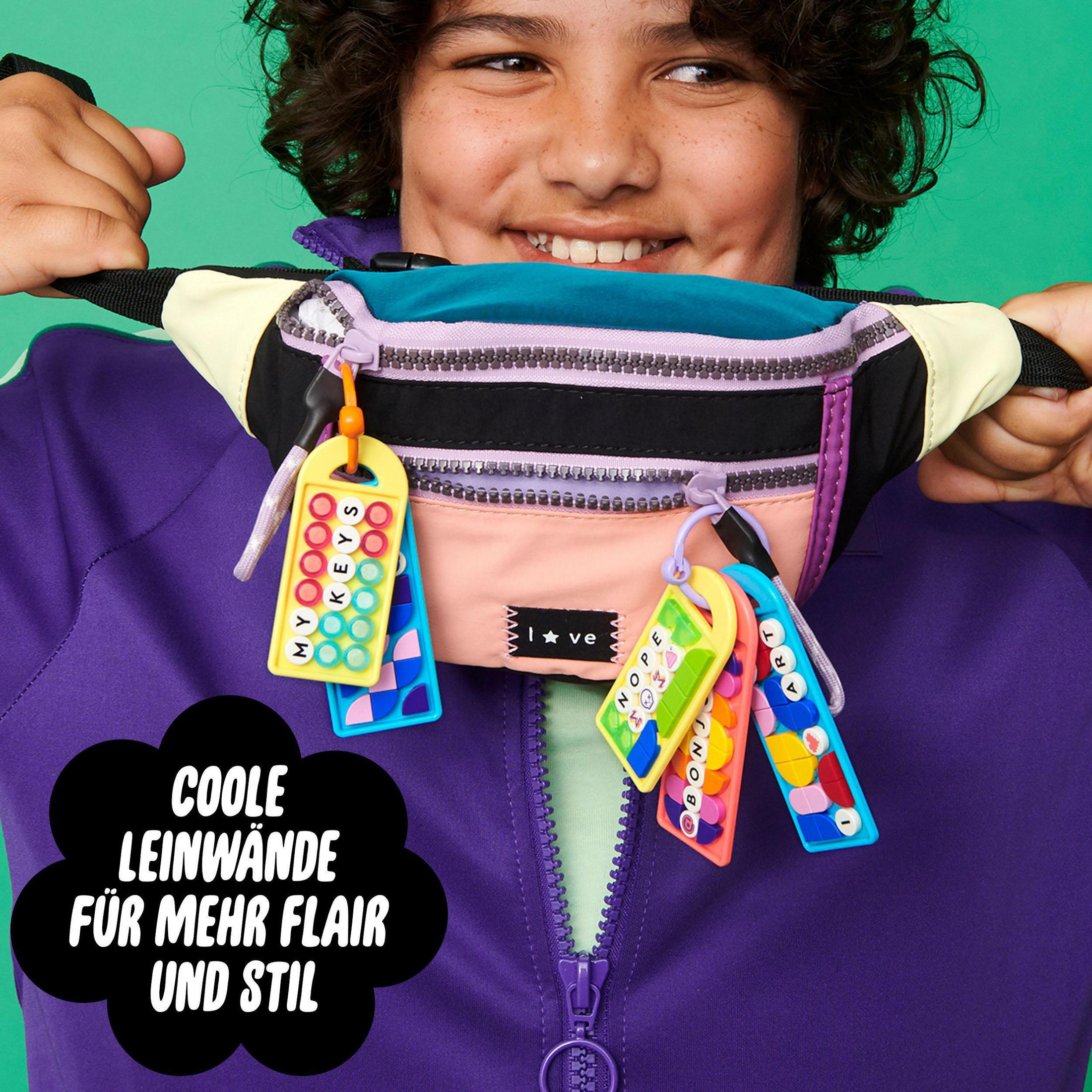 Uśmiechnięty chłopiec z nerką pokazującą breloki z literami. Tekst mówi: 'Fajne płótna dla większego stylu'.