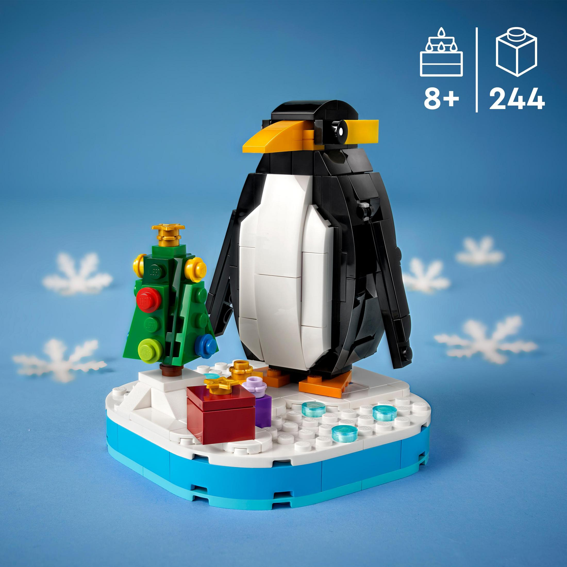 Lego-Pinguin mit Weihnachtsbaum, Geschenk und Schneebasis auf blauem Hintergrund.