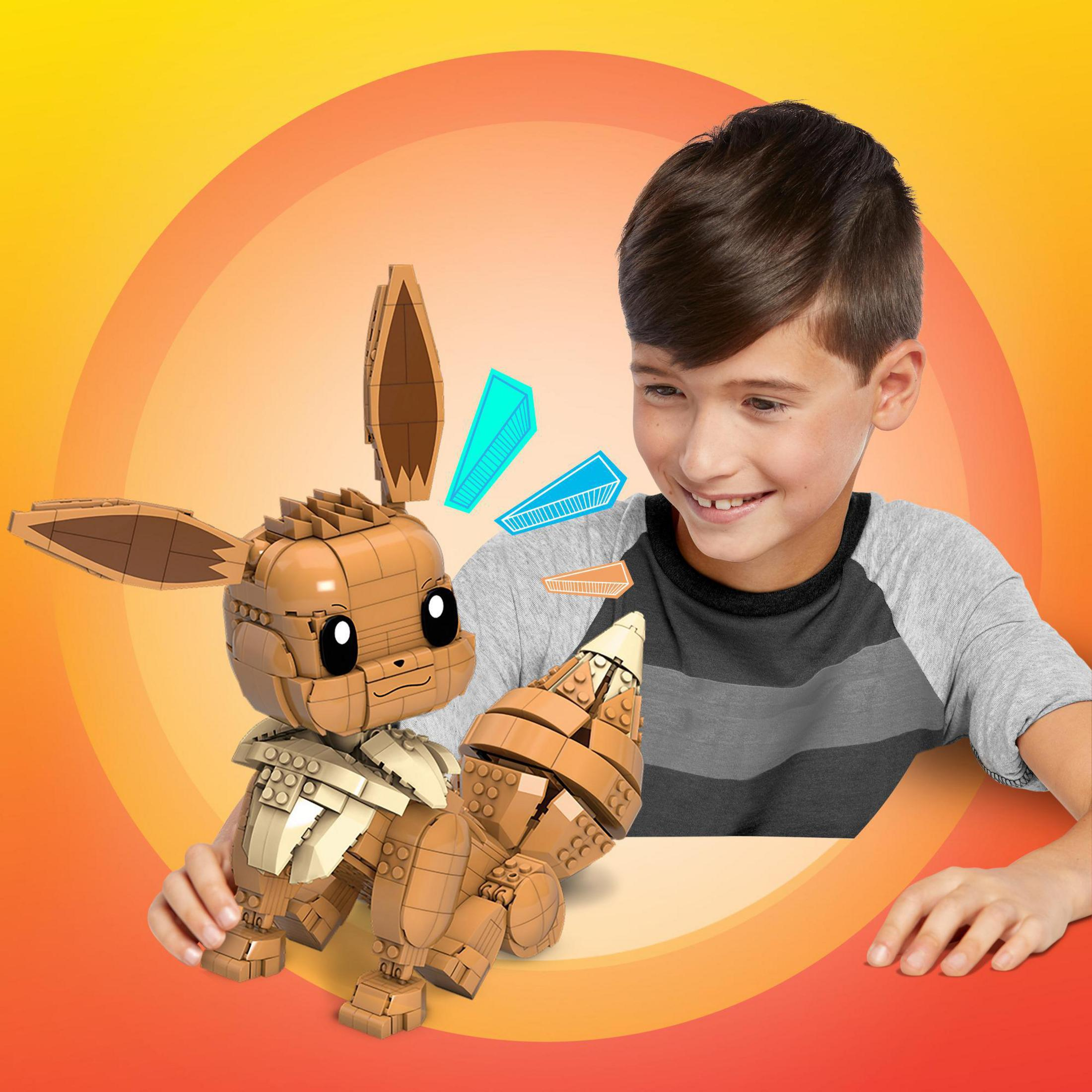 Junger Junge baut eine braune Pokemon Evoli-Figur mit buntem Hintergrund.