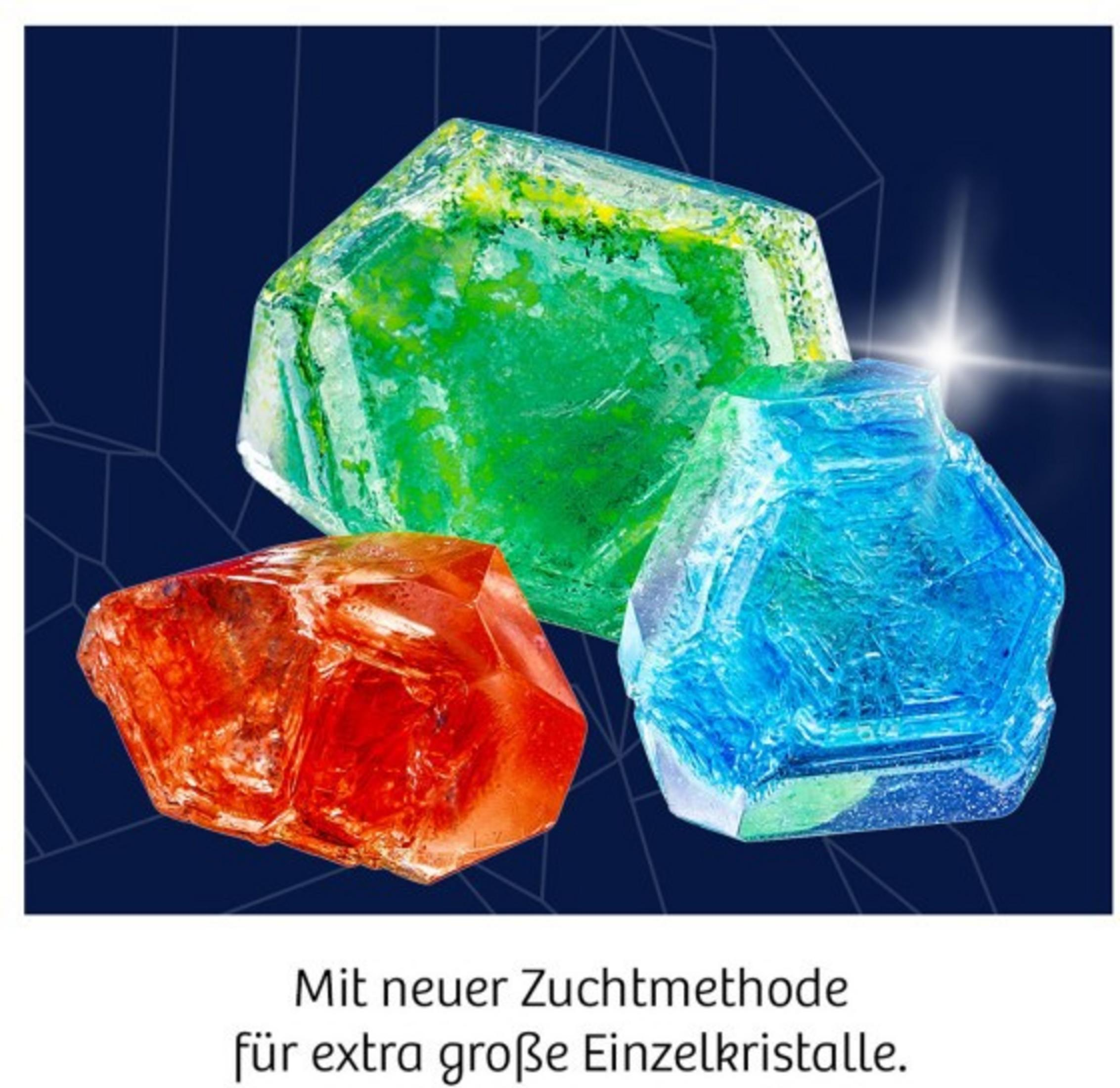 Drei bunte Kristalle in Rot, Grün und Blau vor dunkelblauem Hintergrund.
