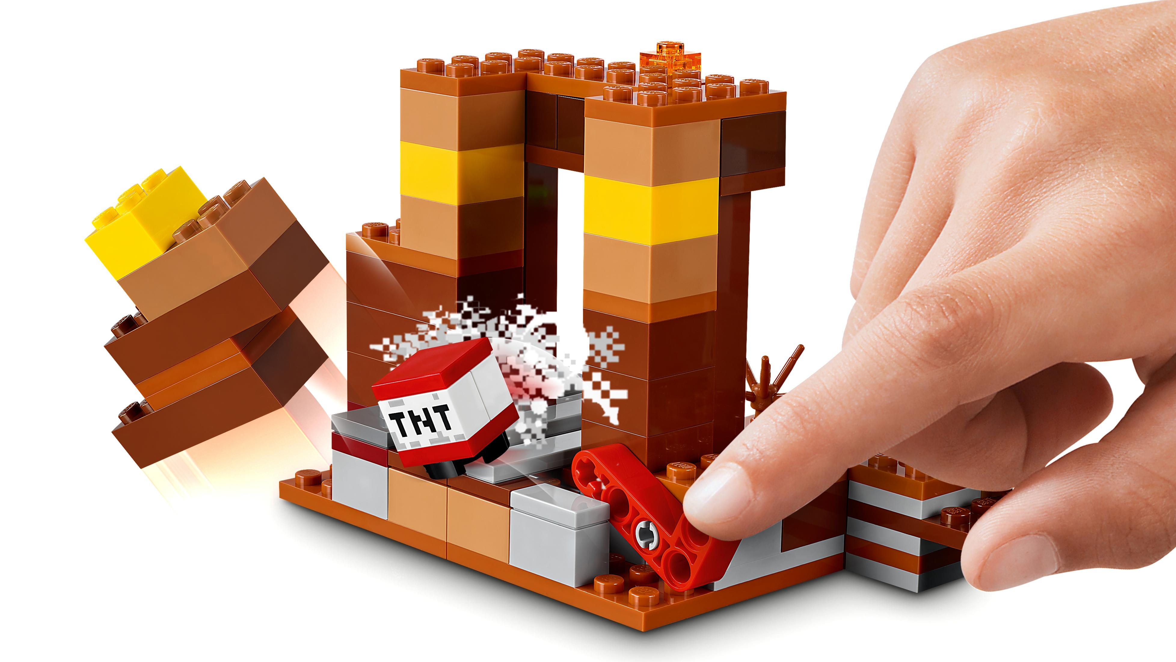 Bir el, patlayan bir TNT bloğu içeren bir Lego seti inşa ediyor, beyaz arka plan.