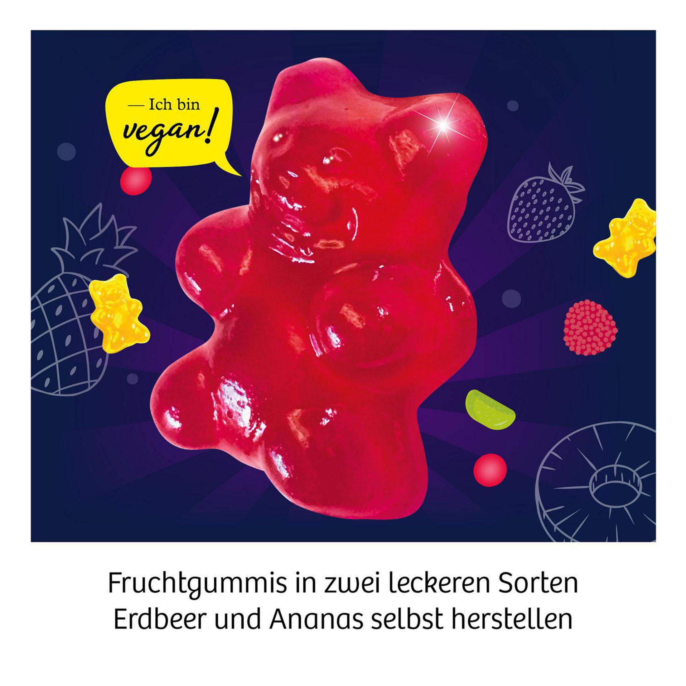 Roter Gummibär mit Sprechblase 'Ich bin vegan!' umgeben von Früchten auf dunklem Hintergrund.
