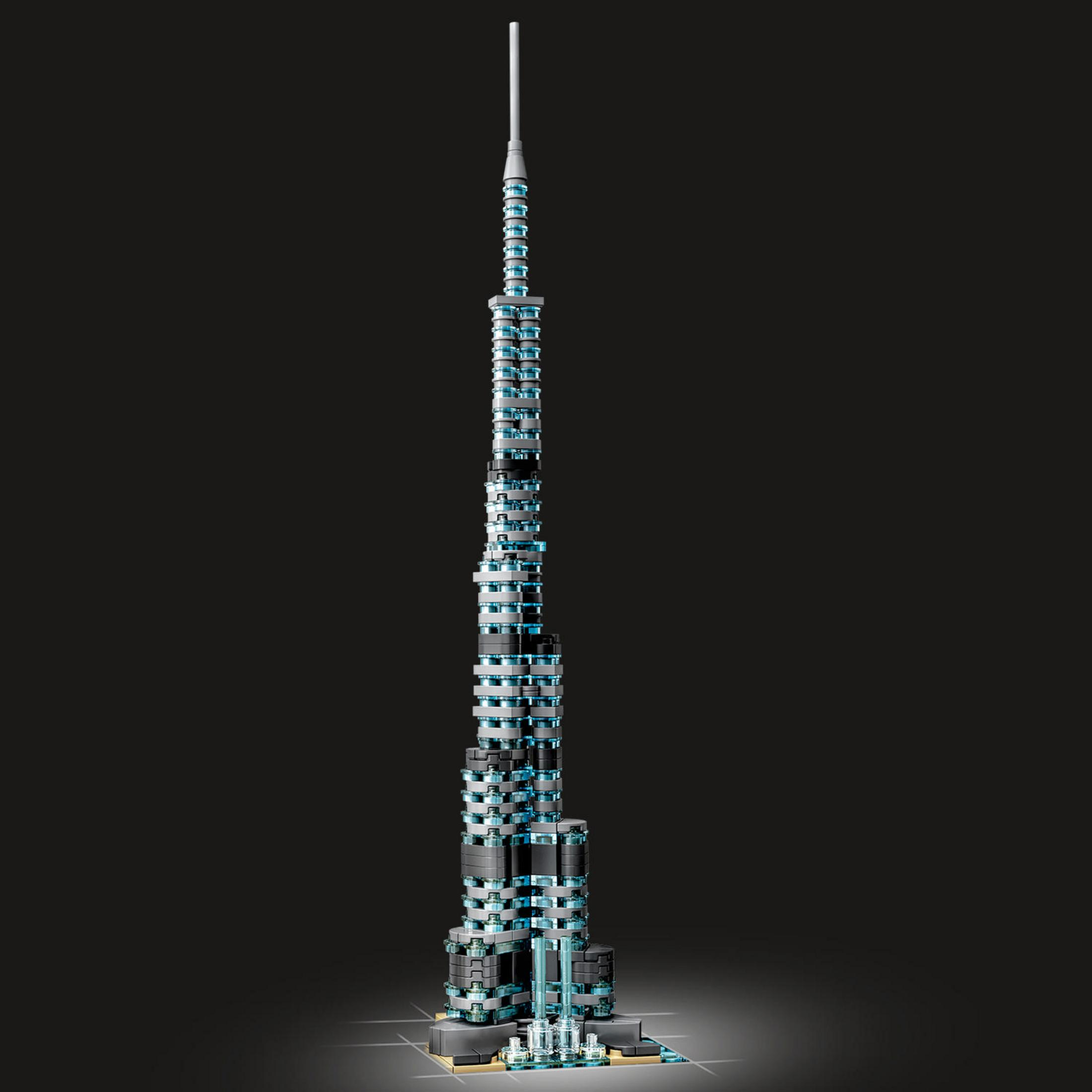 Ein hoher, schlanker Turm aus blau beleuchteten, gestapelten Blöcken, vor dunklem Hintergrund.