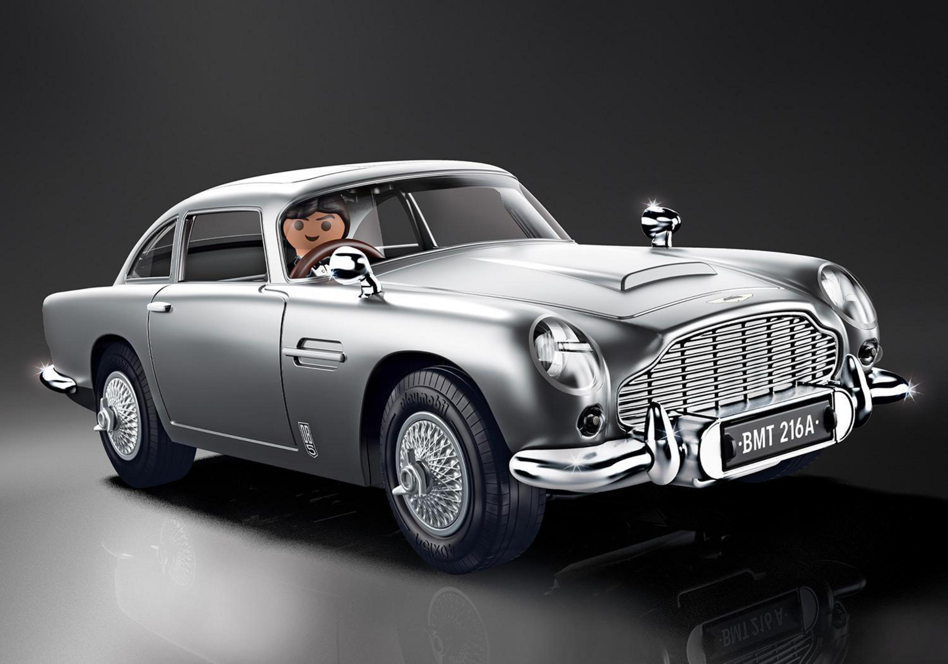 Silver toy car with a driver. Chrome details and a license plate. Dark background.