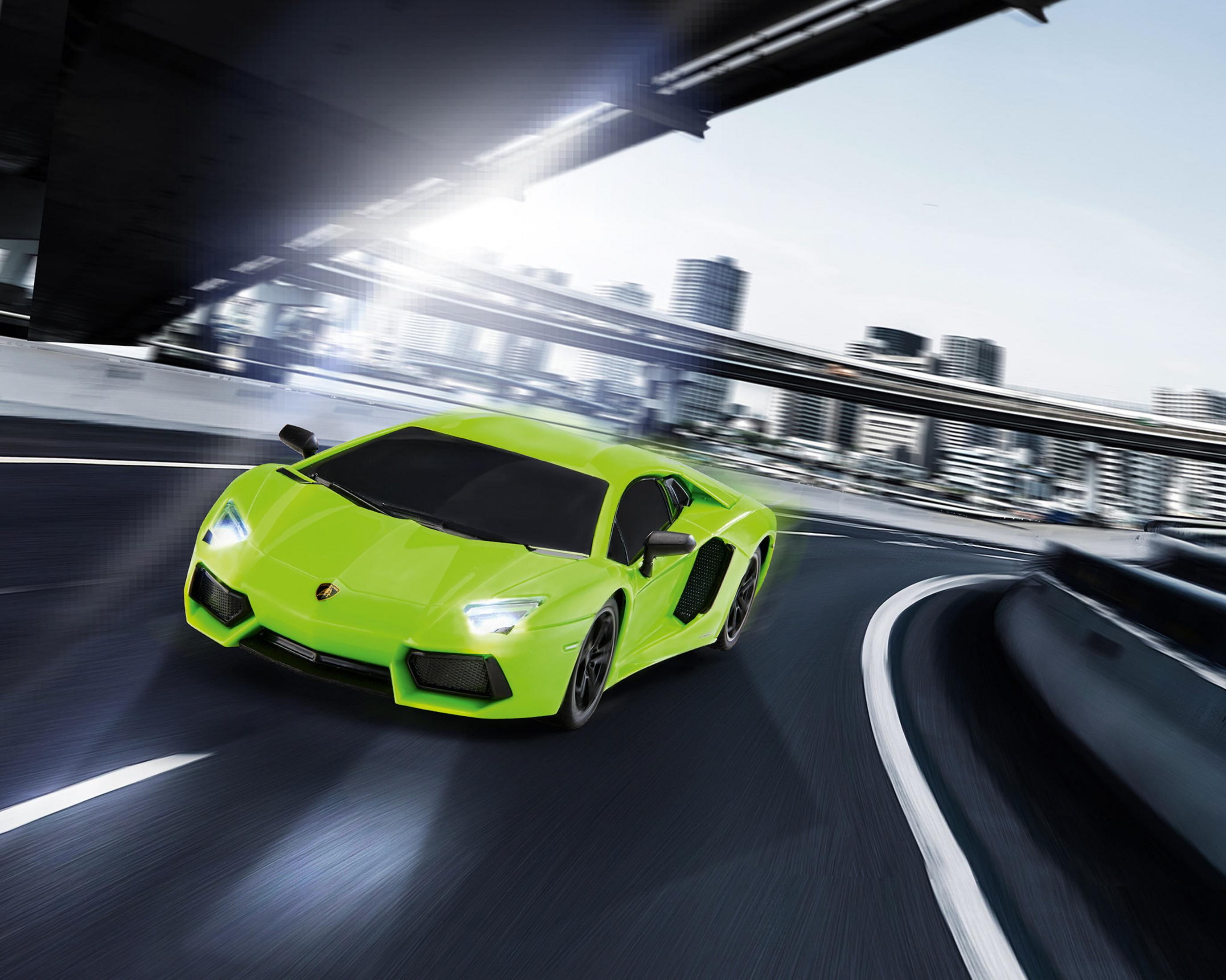 Ein grüner Lamborghini-Sportwagen, der auf einer kurvigen Straße fährt. Der Hintergrund zeigt eine Stadt und den Himmel.