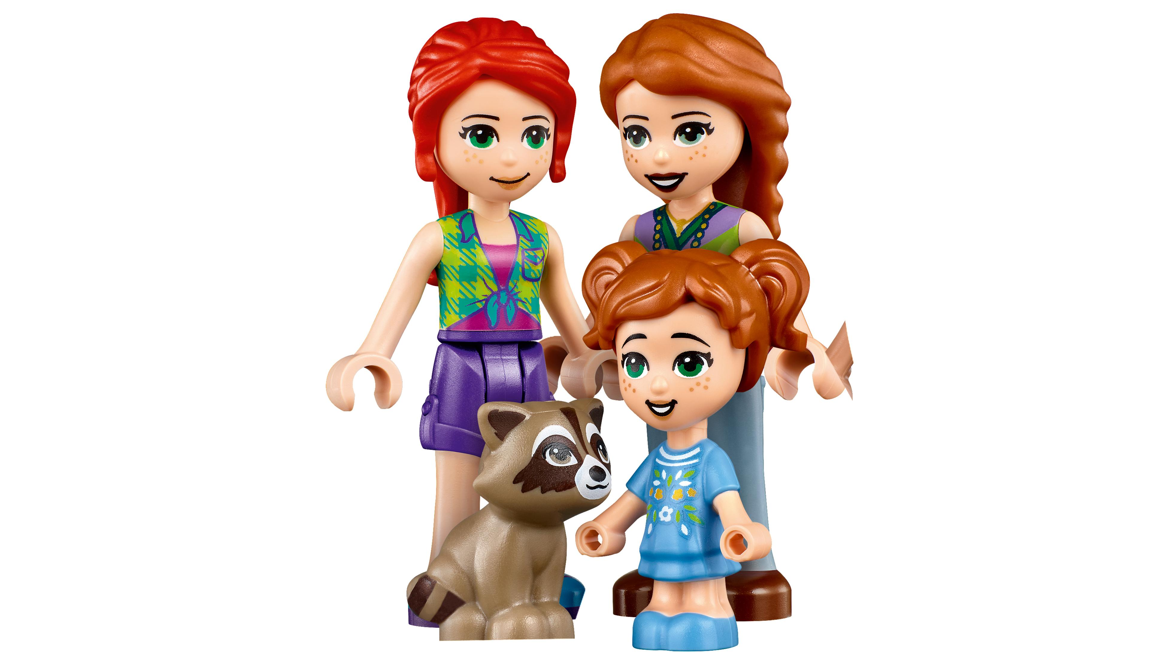 Üç Lego Friends figürü, iki yetişkin ve bir çocuk ve bir rakun. Figürler gülümsüyor.