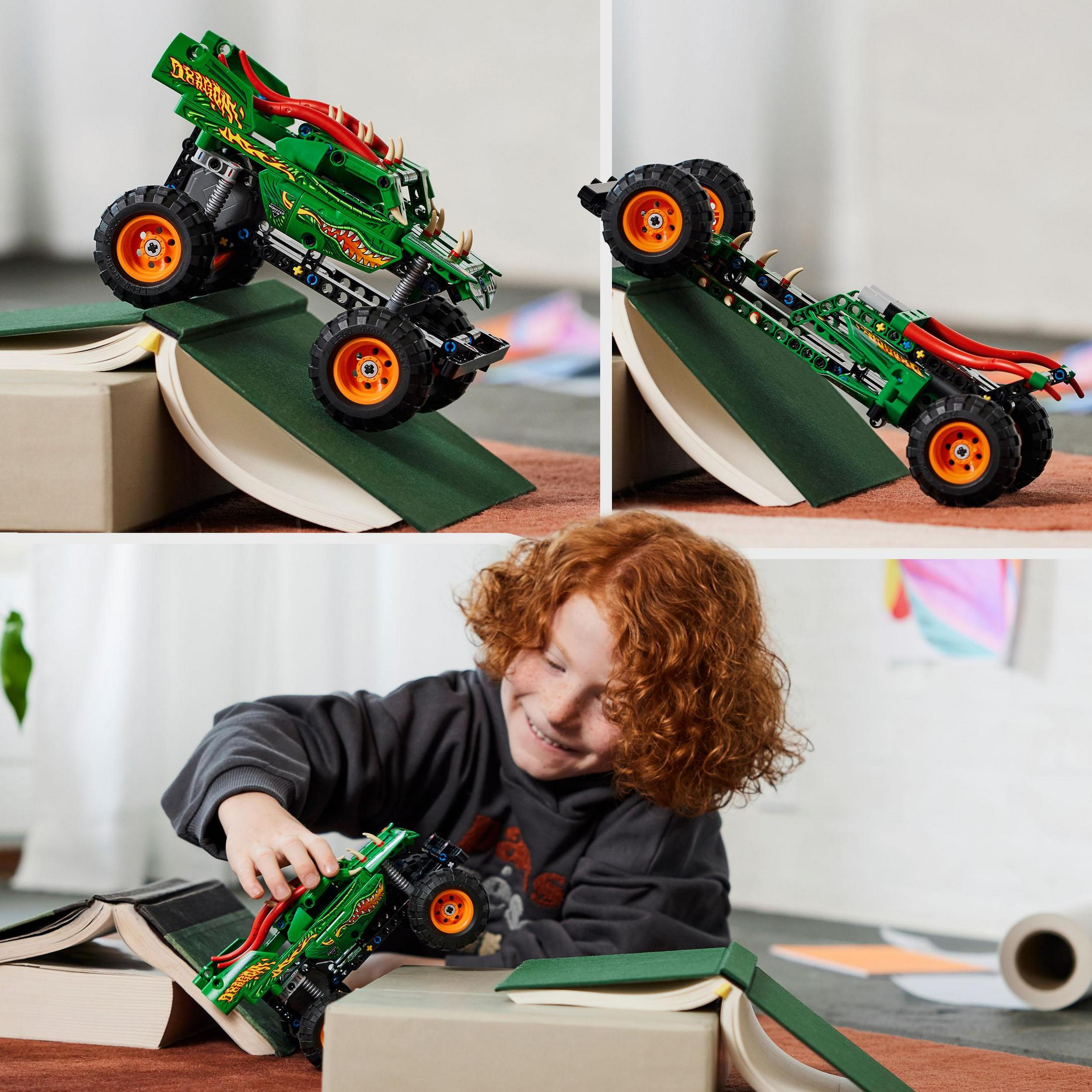 Un bambino che gioca con un monster truck Lego verde. Sfondo bianco.