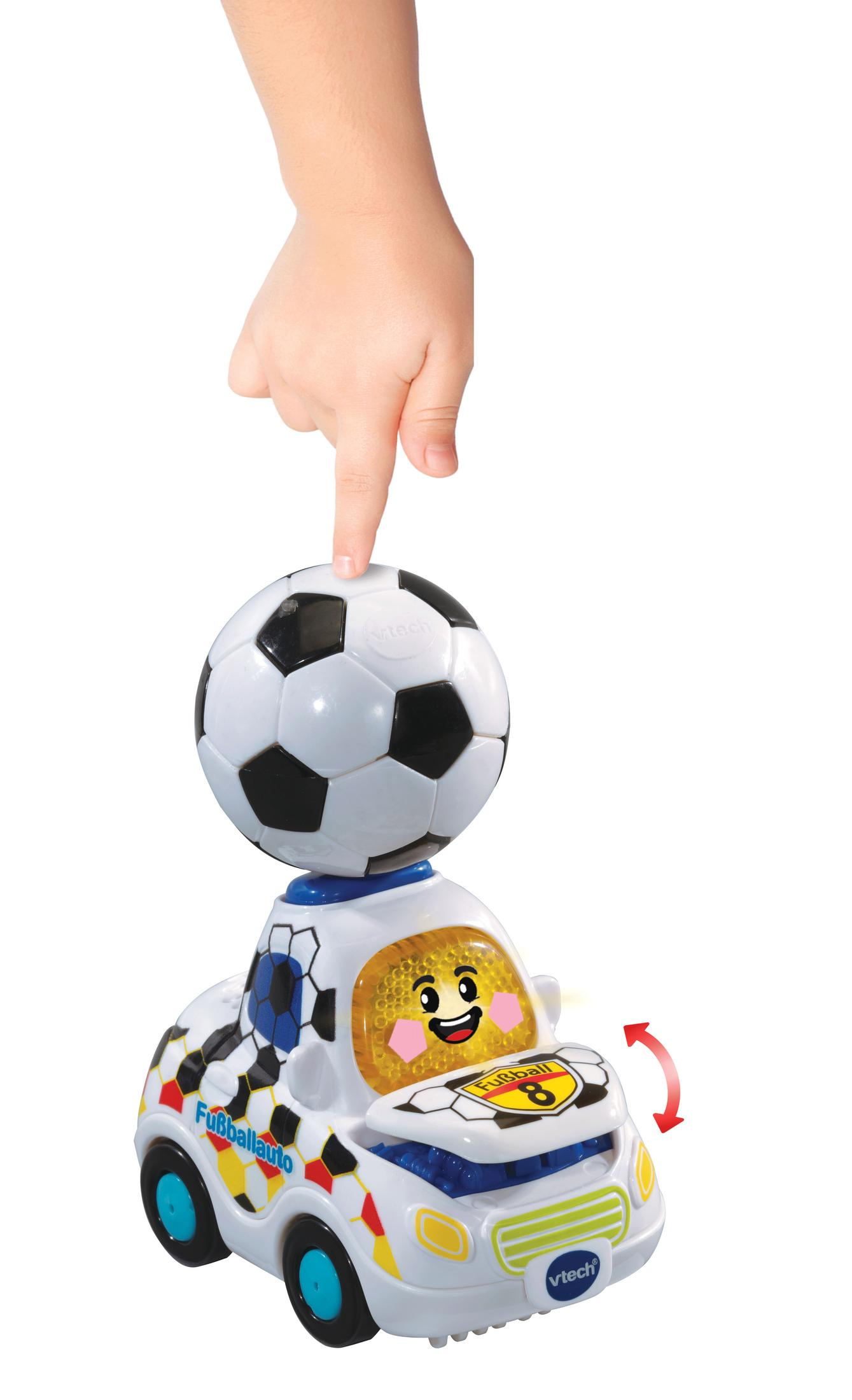 Die Hand eines Kindes zeigt auf einen Fußball auf einem Spielzeugauto mit einem lächelnden Gesicht.