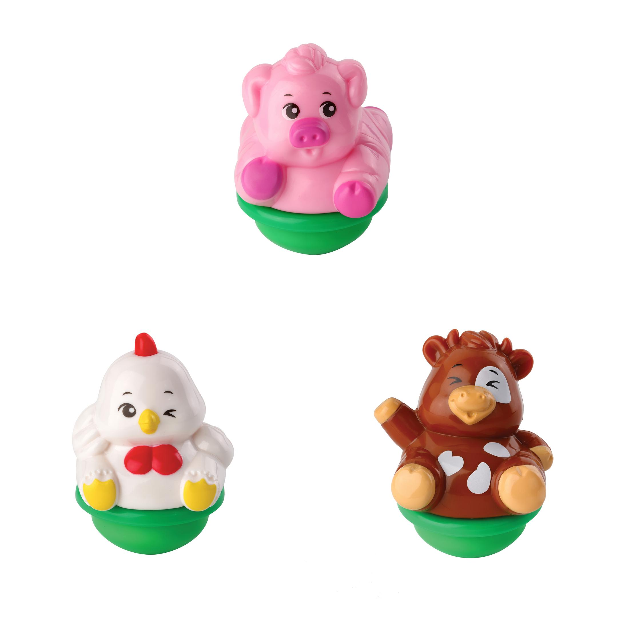 Set von drei Bauernhoftierspielzeugen. Rosa Schwein, weißes Huhn und braune Kuh auf grünen Sockeln.