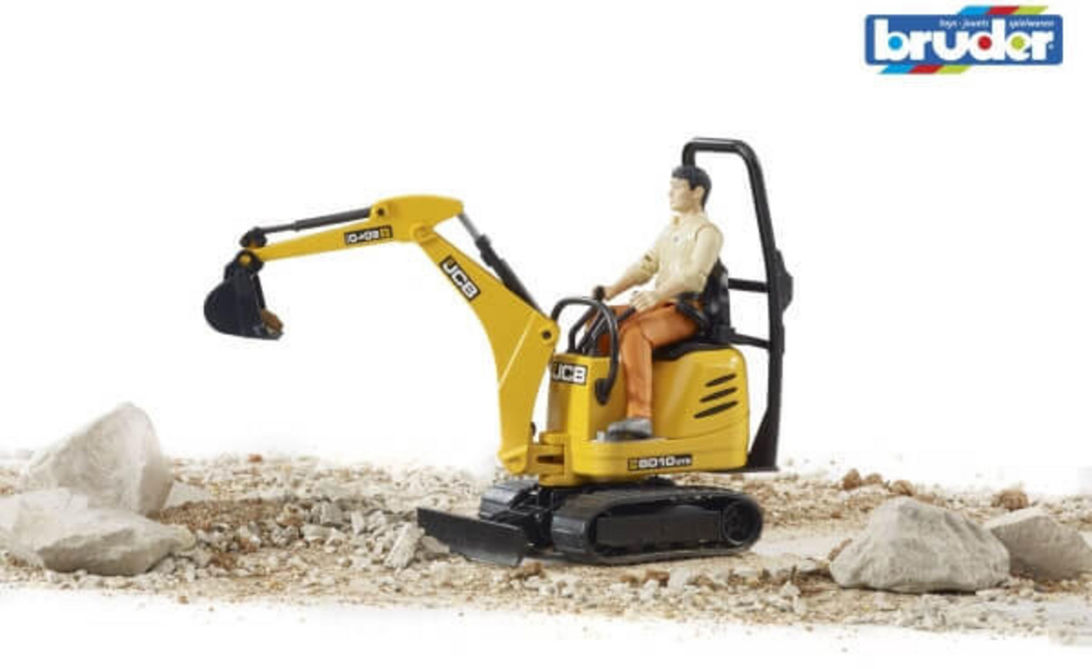 Żółta zabawka koparka z mężczyzną na siedzeniu, na ziemi i skałach.