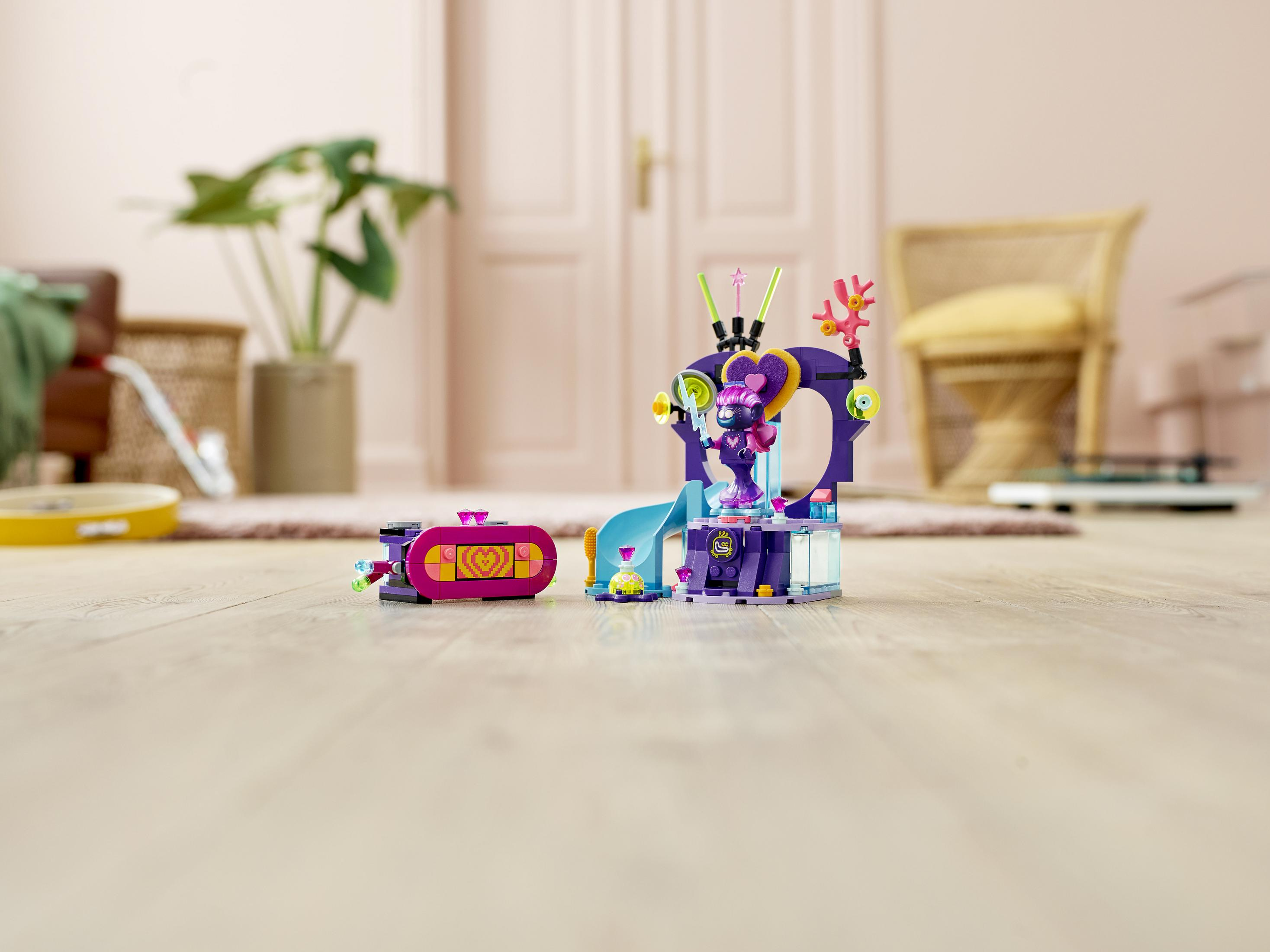 Zestaw Lego Friends na drewnianej podłodze. Zestaw zawiera strukturę i zjeżdżalnię, z fioletową kolorystyką.