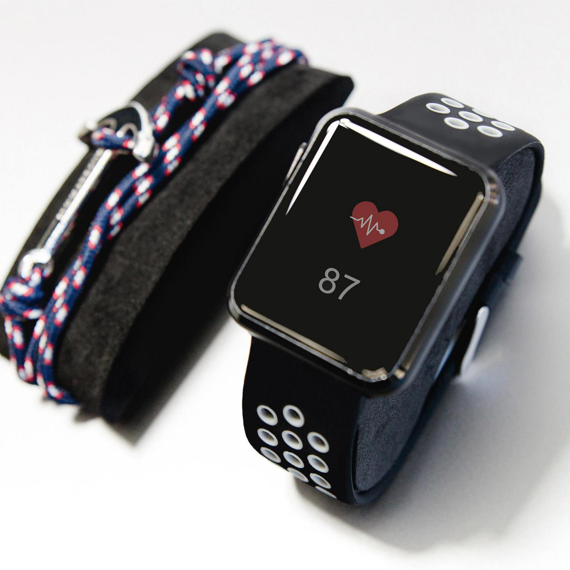 Eine schwarze Smartwatch mit einer Herzfrequenz von 87. Ein Armband ist links. Der Hintergrund ist weiß.