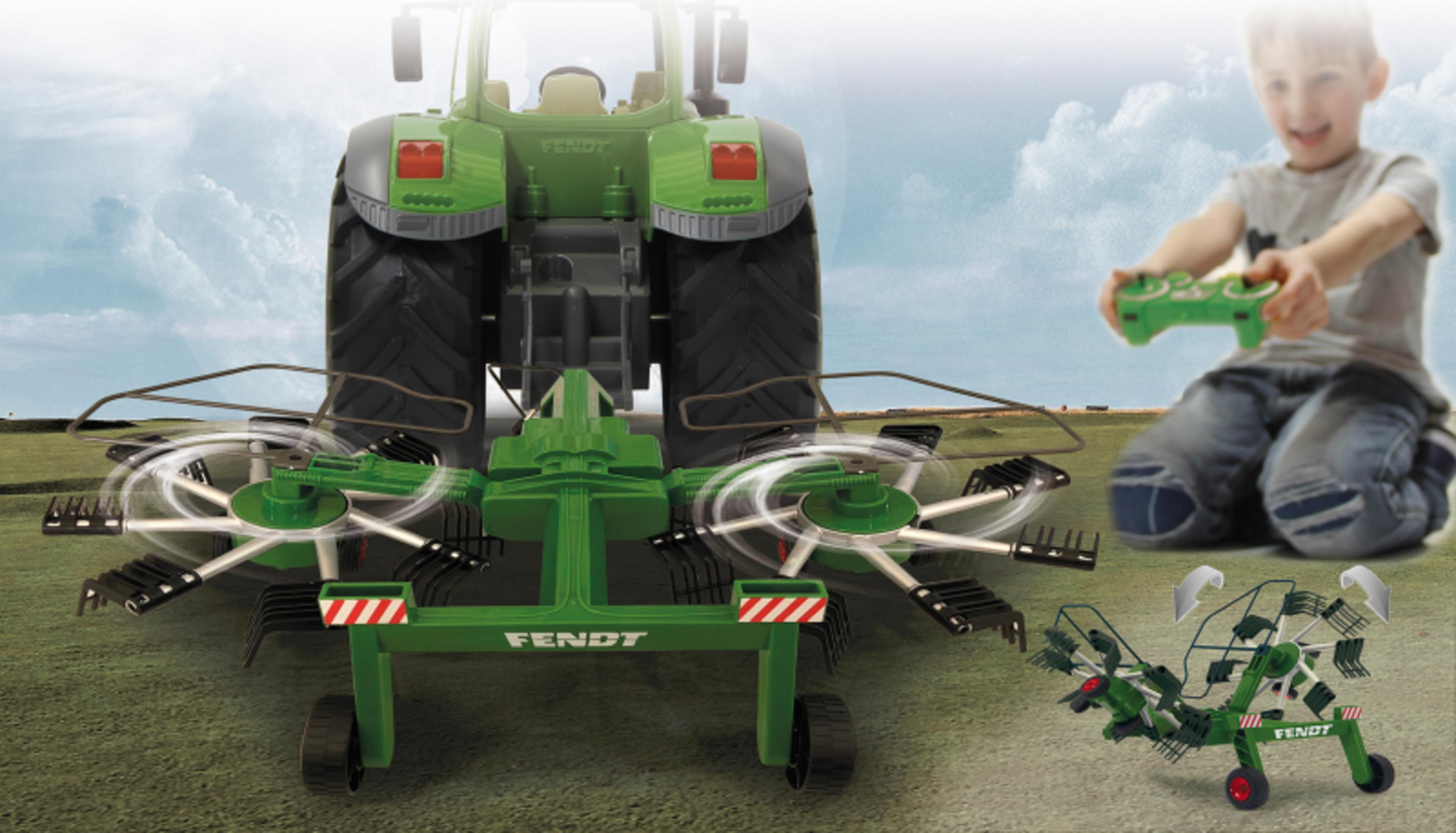 Vista trasera de un tractor Fendt verde con rastrillo rotativo sobre hierba. Niño con mando.