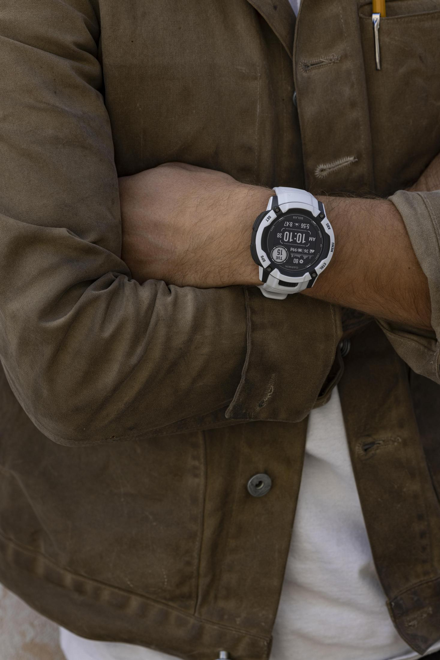 Ein Mann mit einer weißen Uhr am Handgelenk trägt eine braune Jacke.