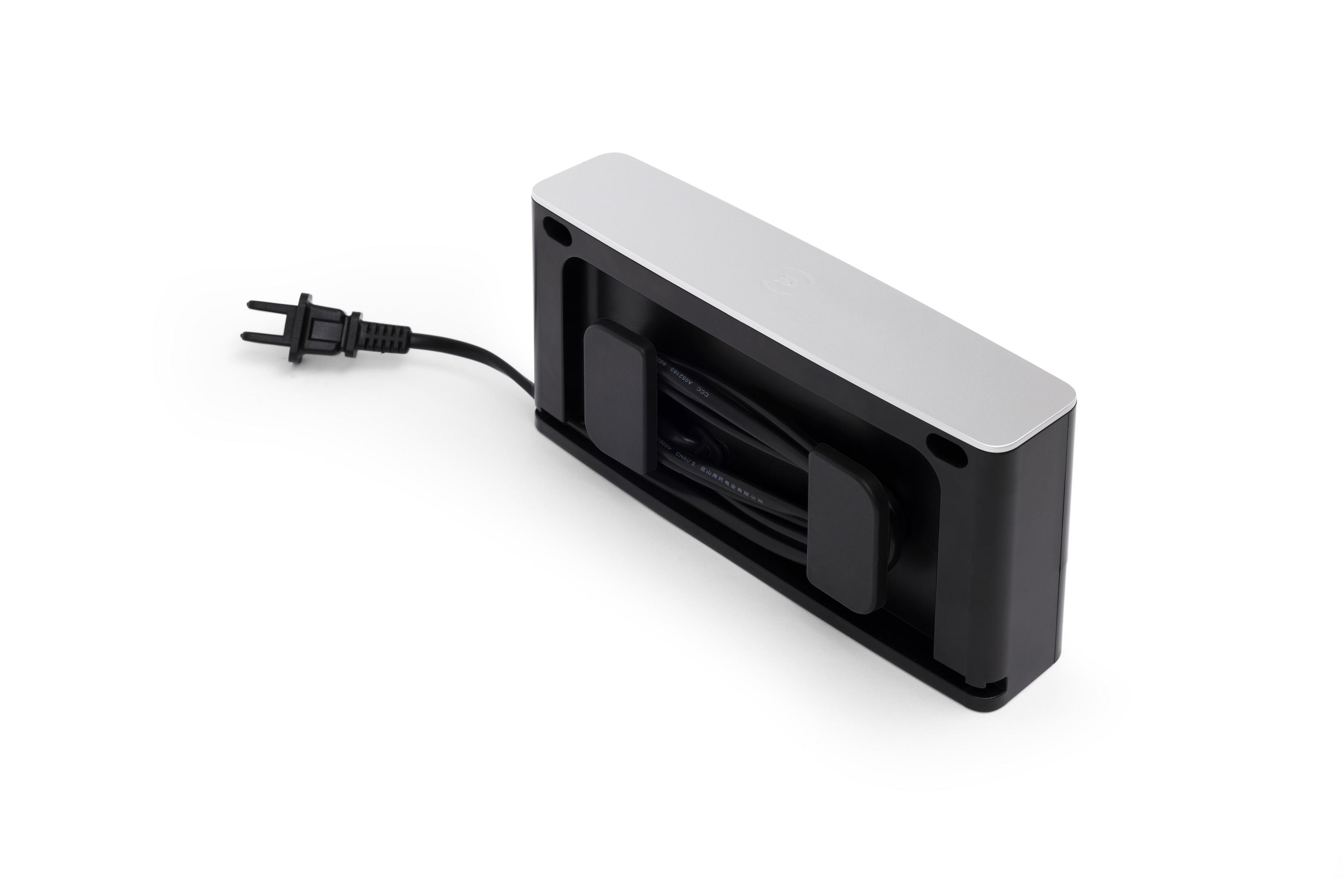 Eine schwarze Steckdosenleiste mit weißer Oberseite. Ein elektrischer Stecker ist angebracht.