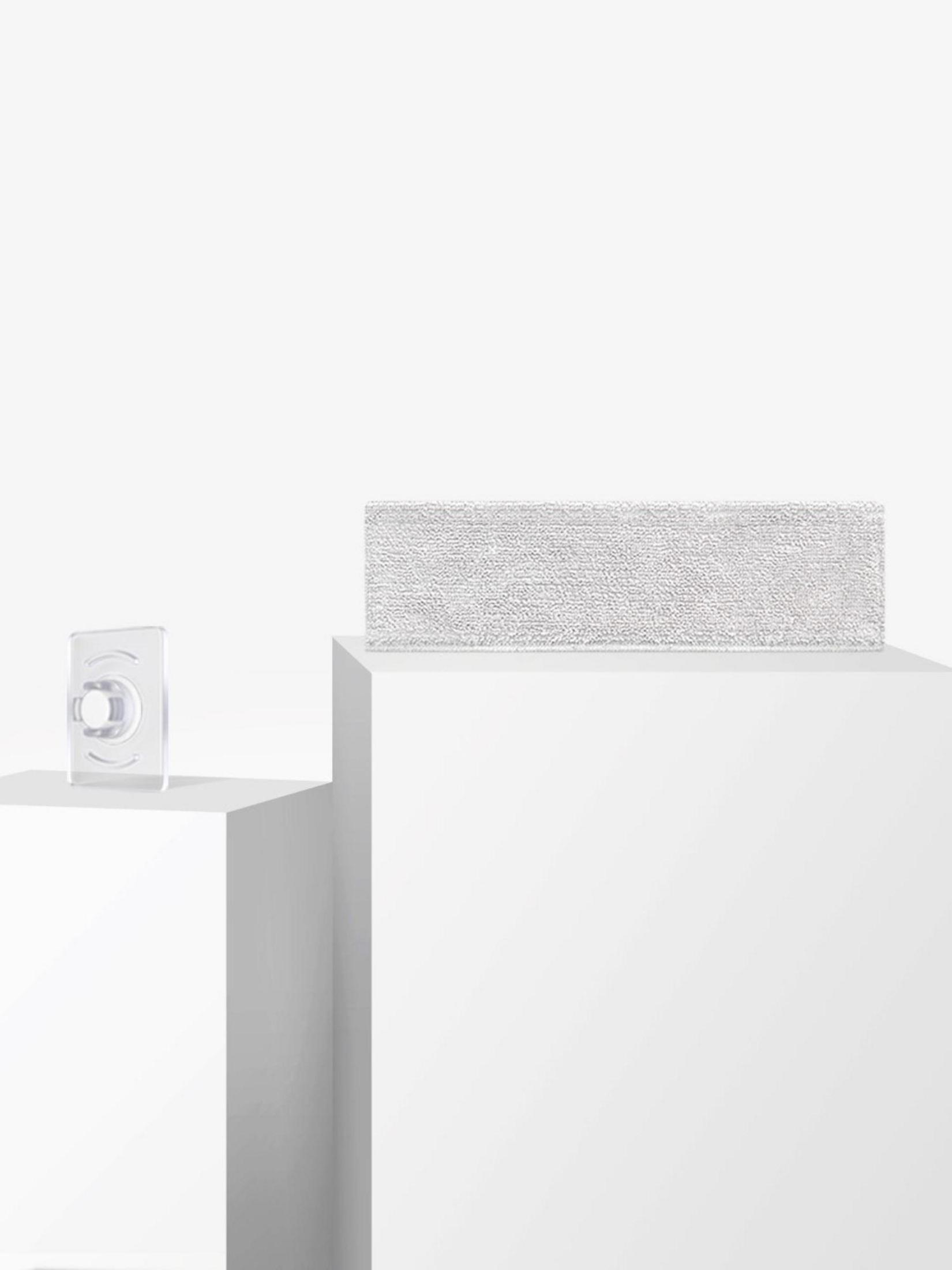 Białe tło z przezroczystym haczykiem samoprzylepnym po lewej i białym przedmiotem na podstawie.