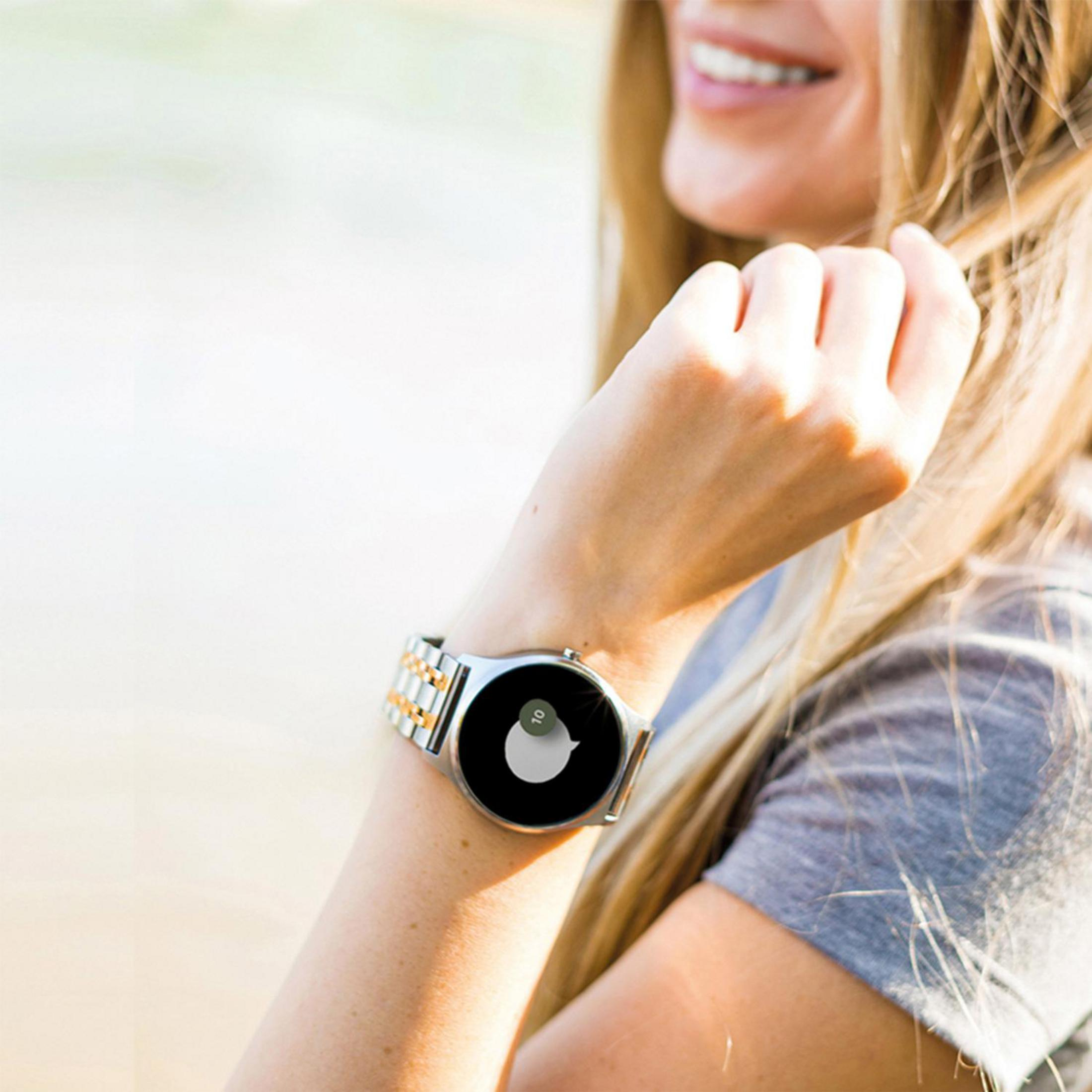 Handgelenk einer Frau mit einer silbernen Uhr, die ein Sprechblasen-Symbol zeigt.
