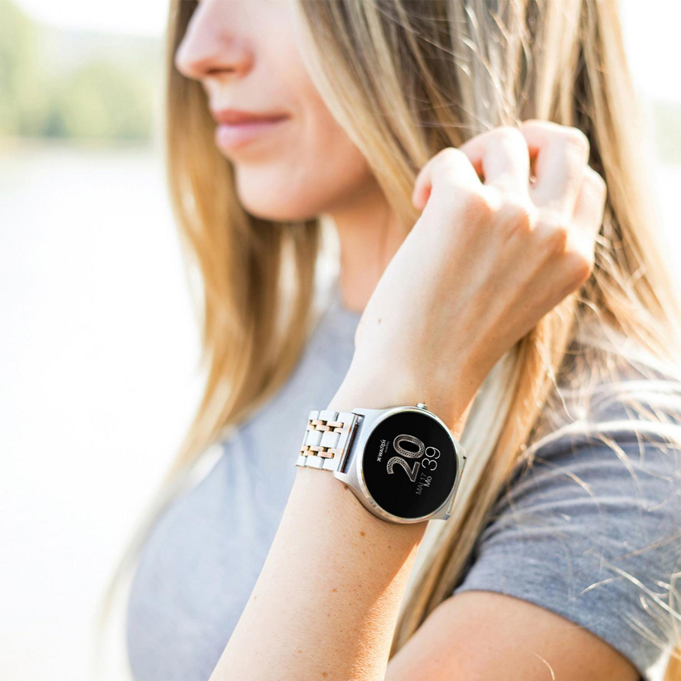 Eine Frau trägt eine silberne Uhr mit schwarzem Bildschirm.