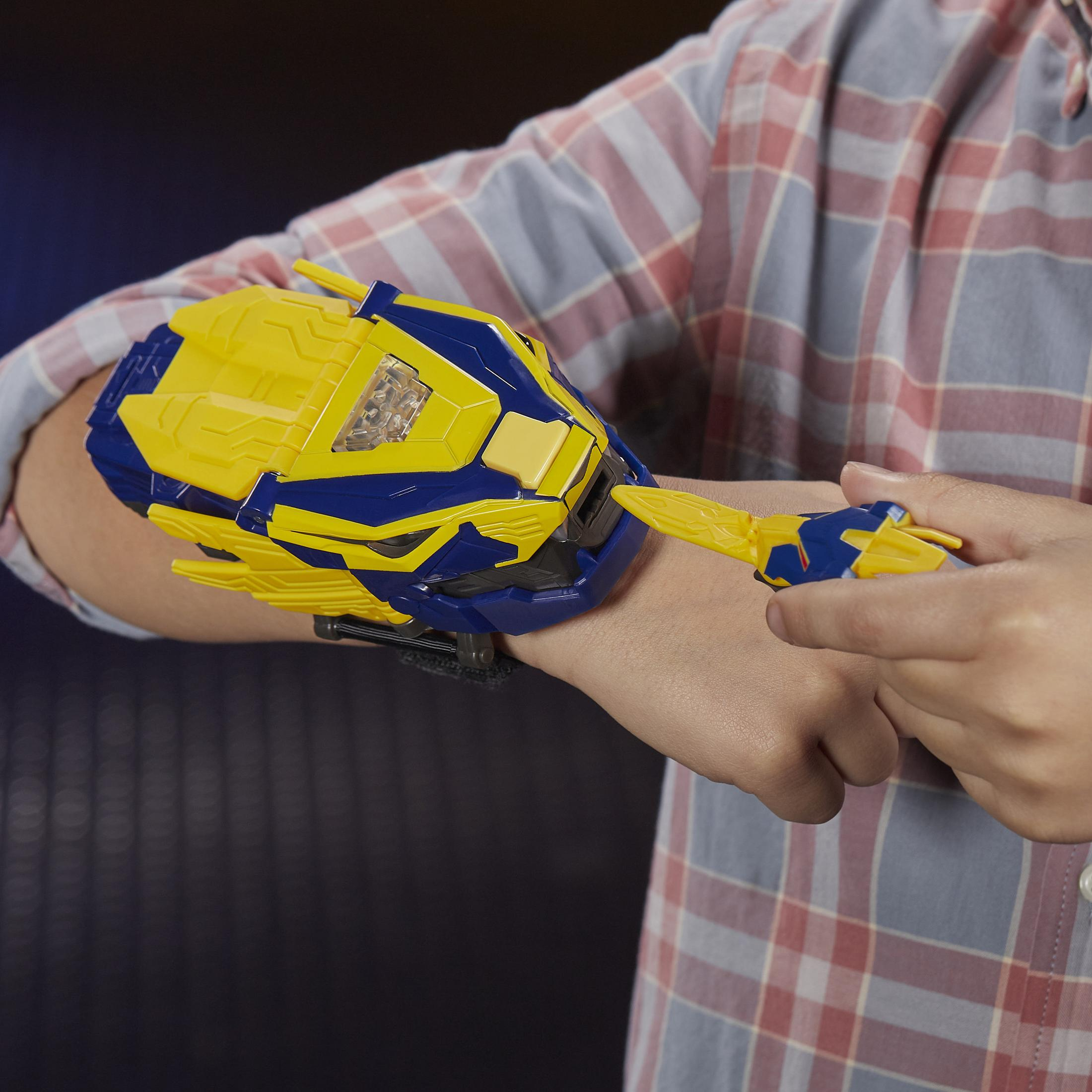 Osoba trzymająca żółto-niebieskie urządzenie zabawki na ramieniu z niebieską opaską.