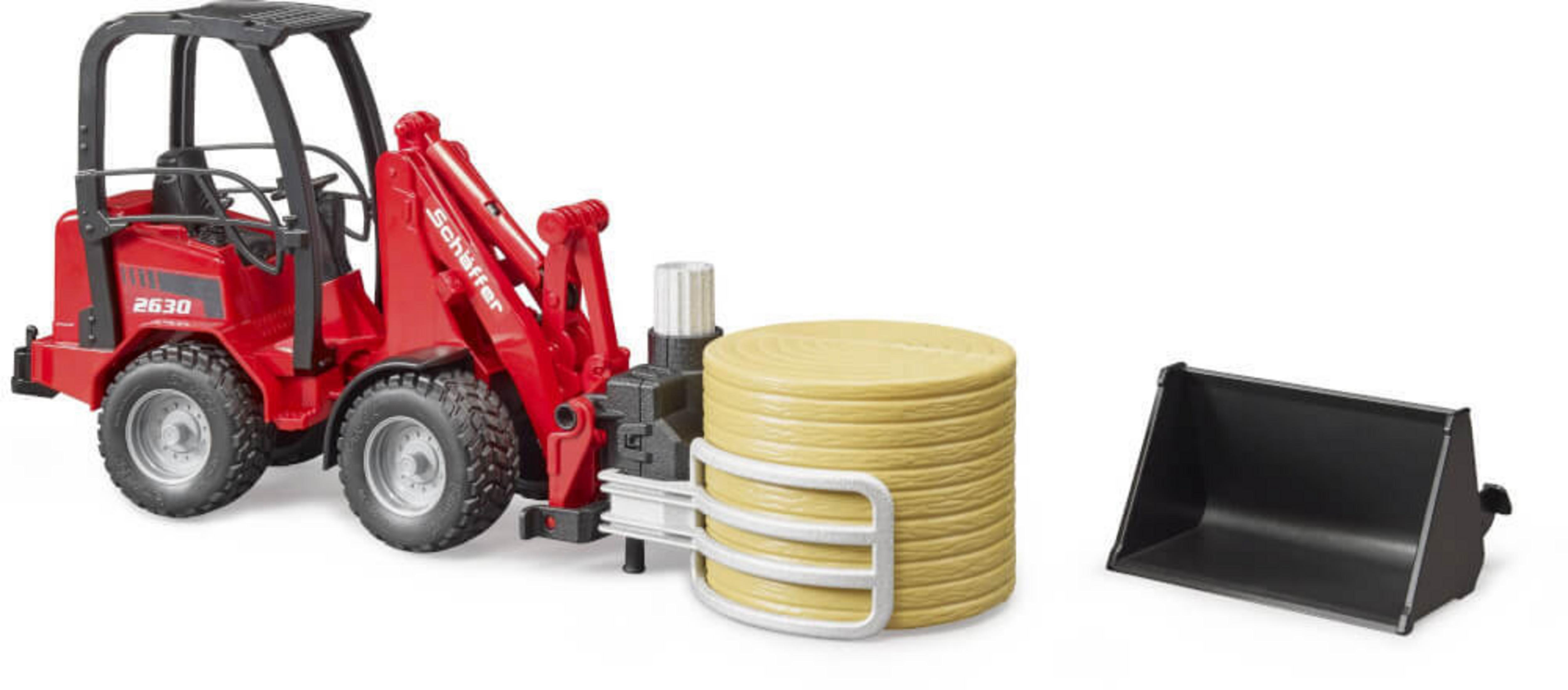 Roter Spielzeugtraktor mit Heuballenheber und gelbem Heuballen. Weißer Hintergrund.