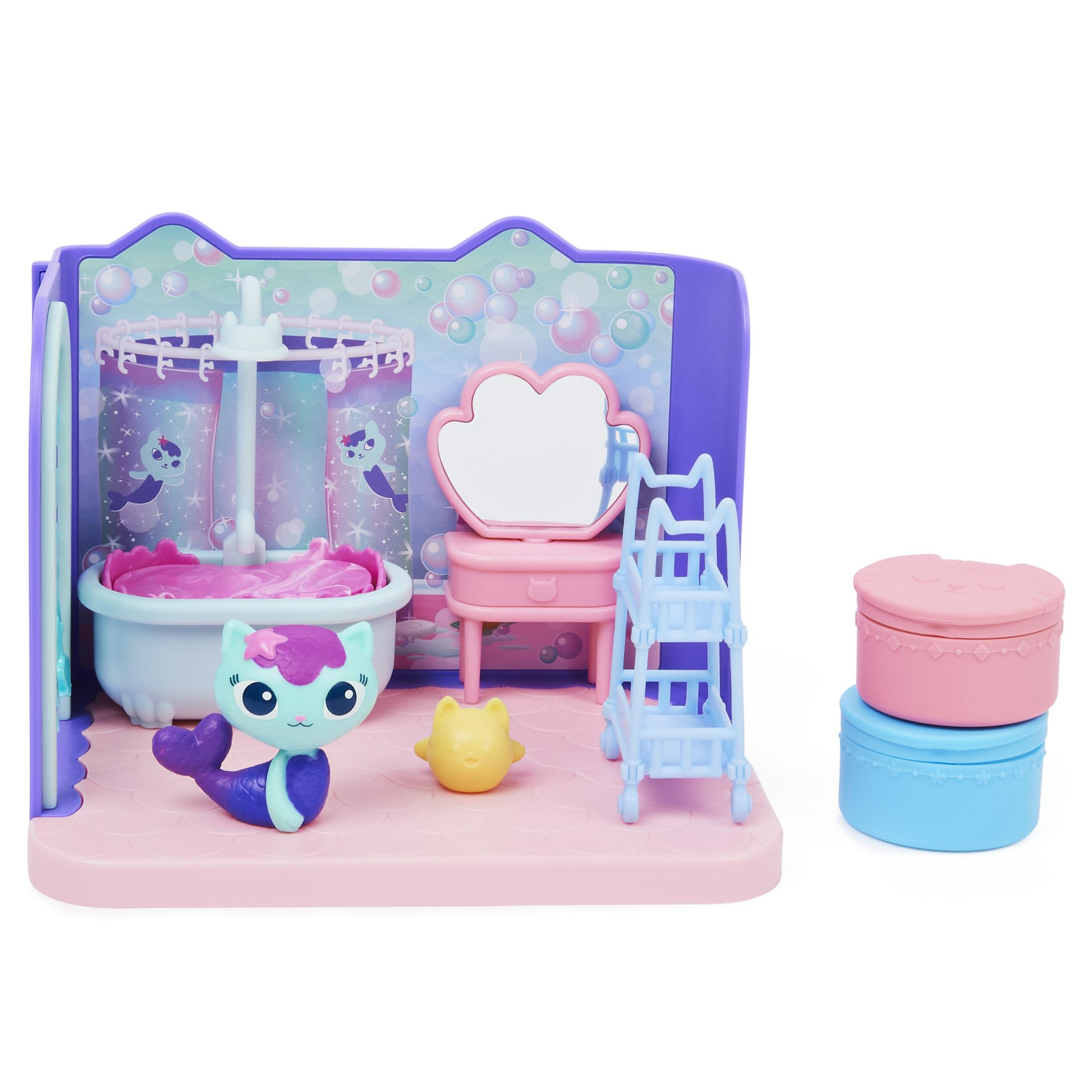 Eine Puppenhaus-Badezimmerszene mit einer Meerjungfrauenpuppe, Badewanne und anderem Zubehör. Rosa und lila Farben.