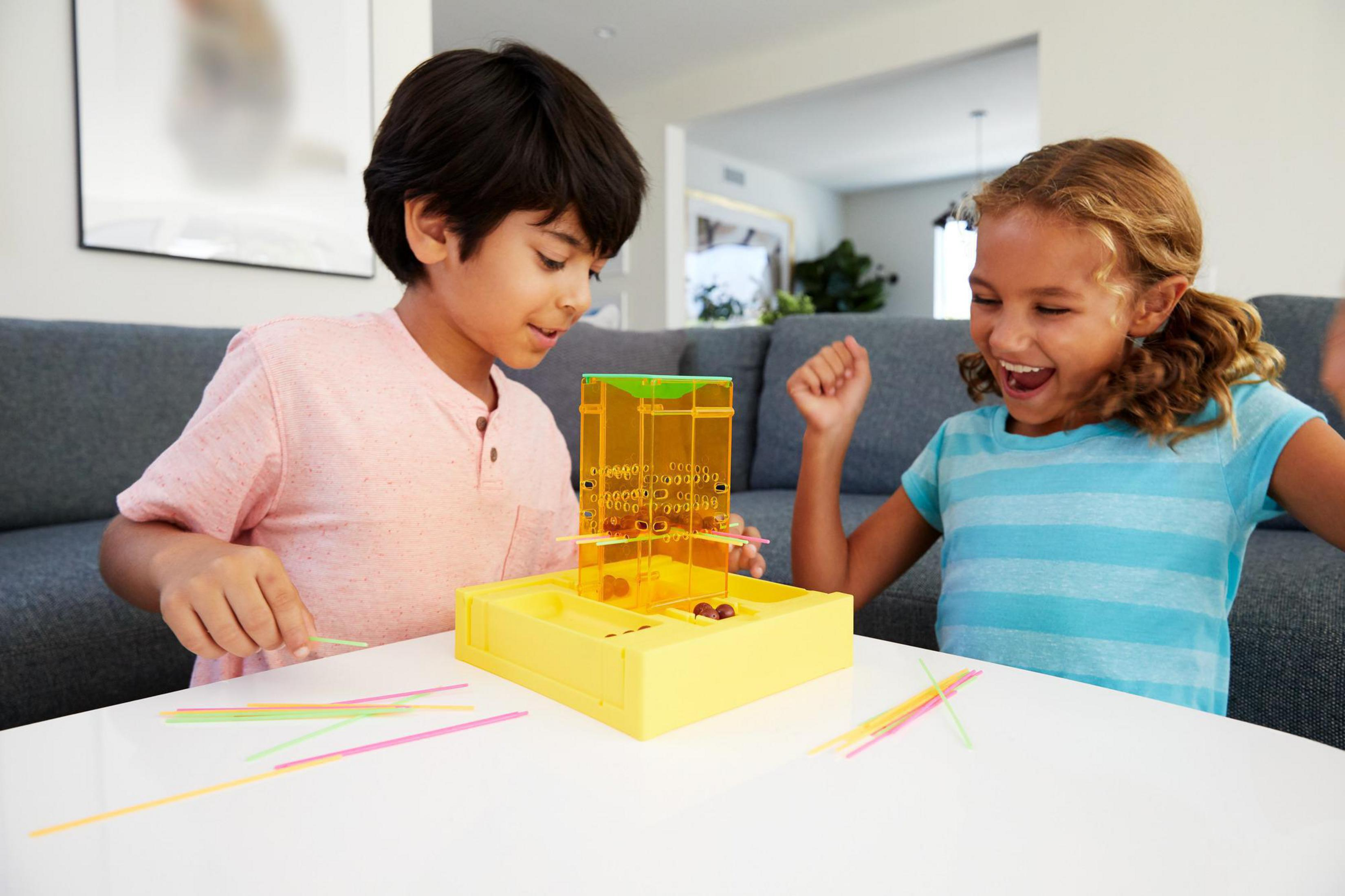 Kinder spielen ein Spiel. Junge und Mädchen spielen ein Turmspiel mit Stöcken und Murmeln.