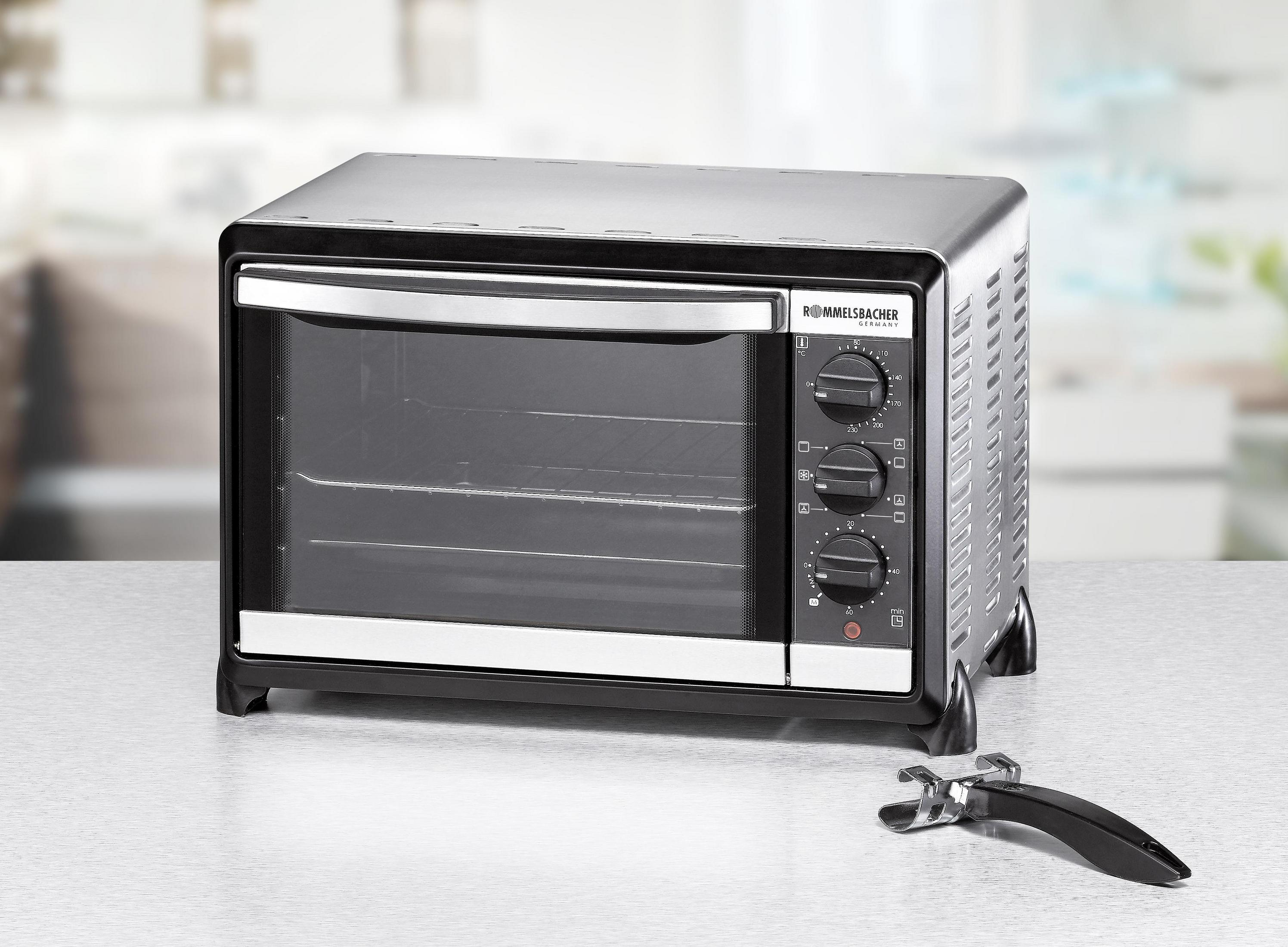 Czarny i srebrny piekarnik z trzema pokrętłami, uchwytem i szklanymi drzwiami. Stoi na stole.