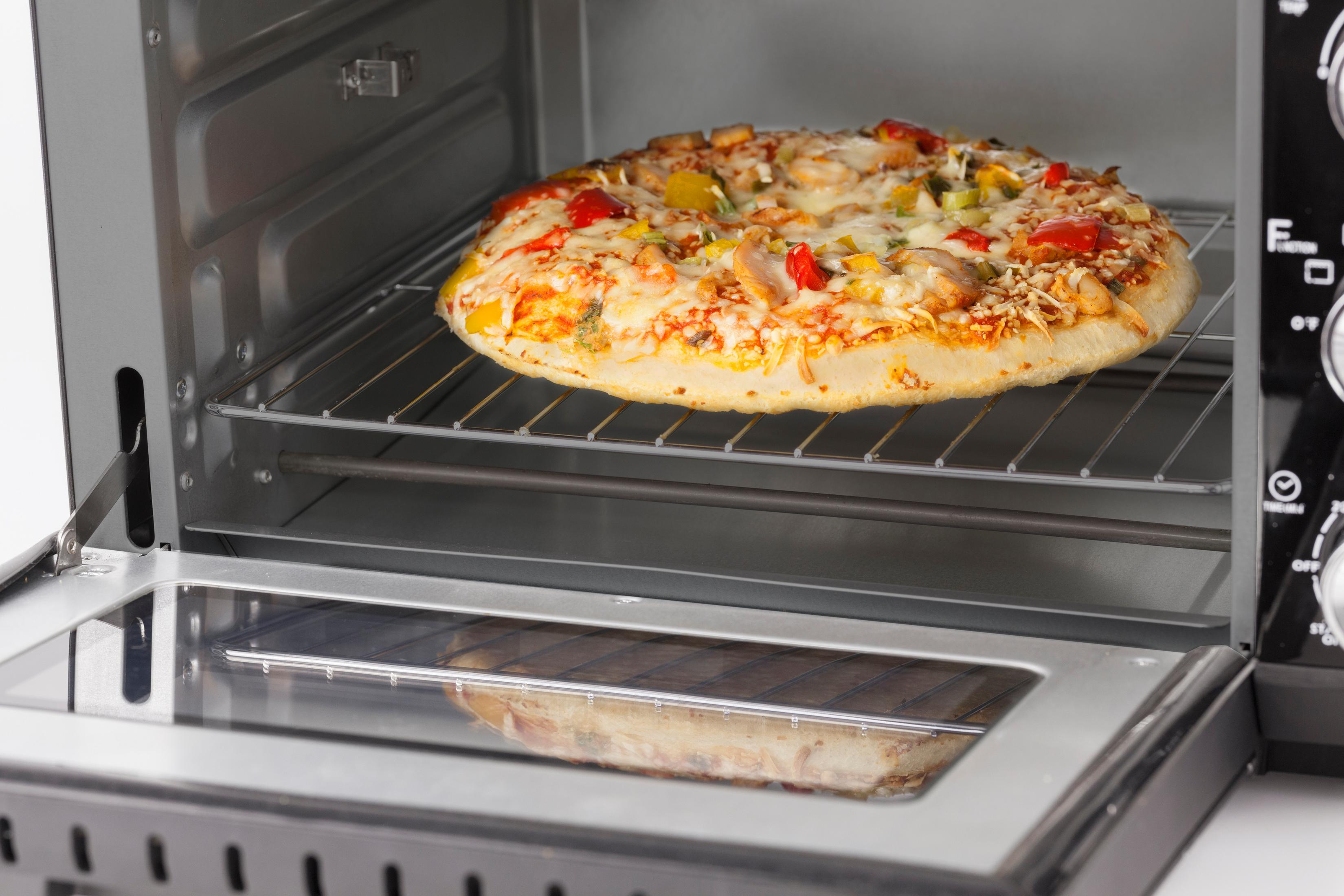 Pizza in un forno nero, con la porta aperta, che mostra il cibo all'interno.