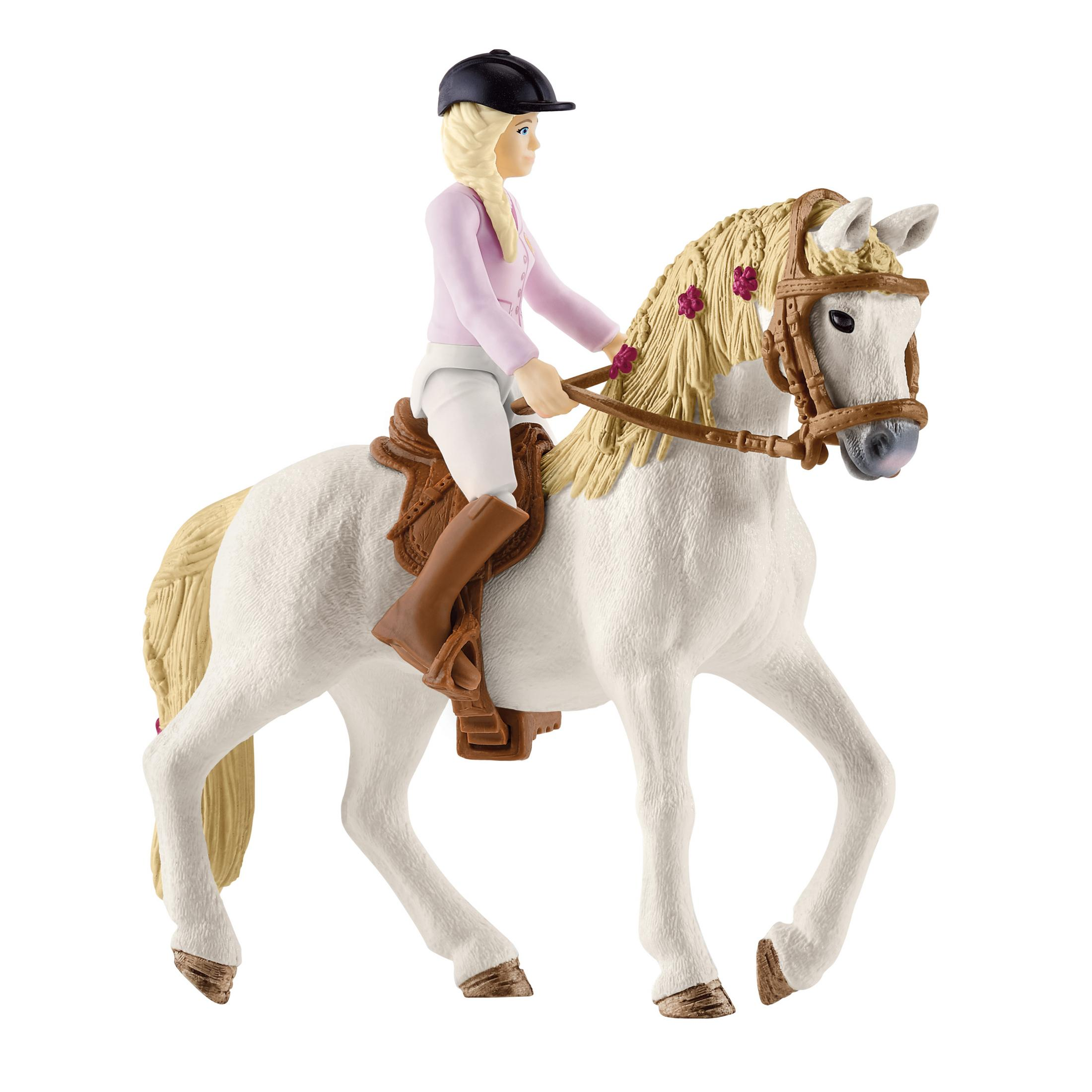 Spielzeugpferd mit Reiter. Das Pferd ist weiß, der Reiter trägt ein rosa Hemd und einen schwarzen Helm.
